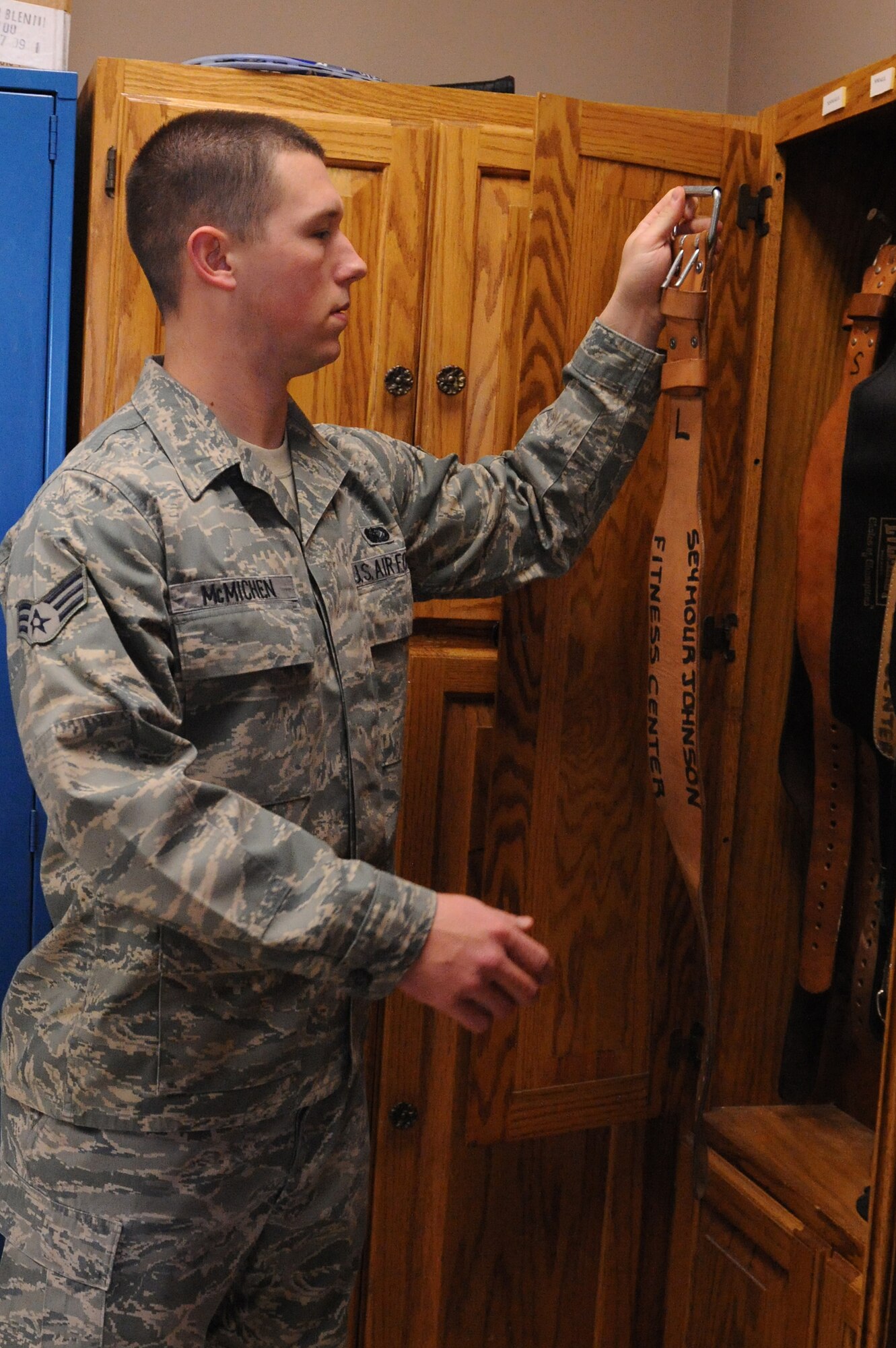 Senior Airman Adam McMichen, 4th Force Support Squadron fitness and sports specialist, grabs a weight belt for a customer on Seymour Johnson Air Force Base, N.C., Jan. 4, 2010. Seymour Johnson's fitness and sports center has items customers may sign out during a workout session such as weight belts, goggles, locks, rackets, volleyballs, basketballs and footballs.  (U.S. Air Force photo by/Senior Airman Whitney Lambert)
