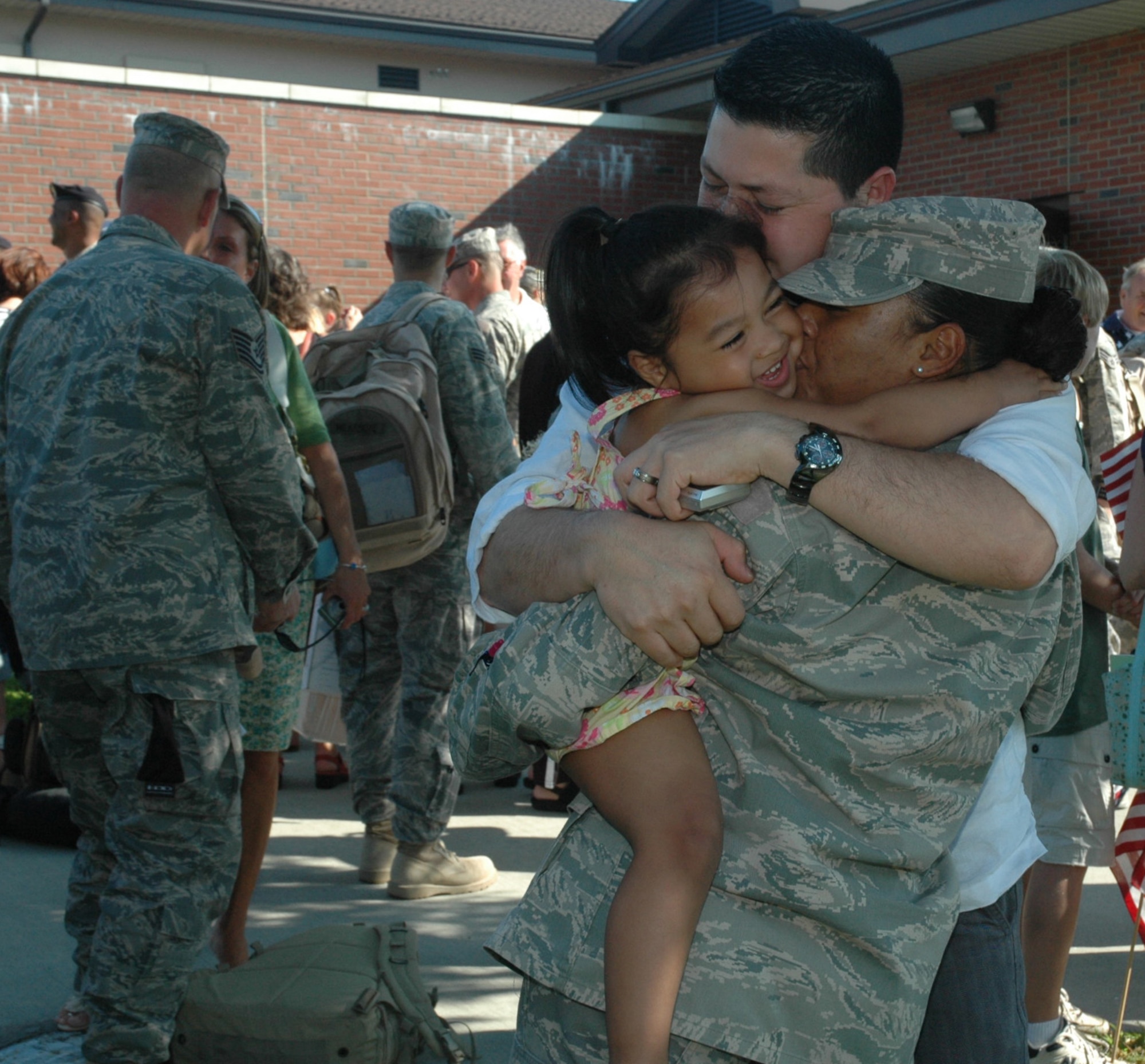 The family of a staff sergeant from the 439th Security Forces Squadron celebrates the NCO's return to Westover from an overseas deployment. Base resources for deployers and families include the Yellow Ribbon program, and the Airmen and Family Readiness Center, which provide benefits information to families while loved ones are away, and upon their return. (US Air Force photo/Tech. Sgt. Andrew Biscoe)