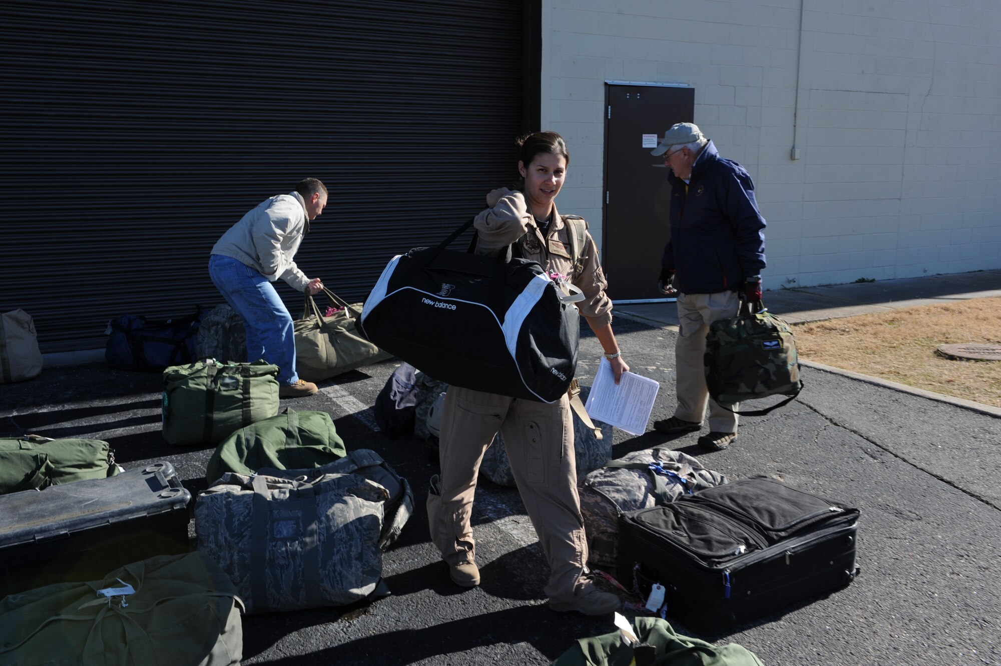 Capt. Carrie Donohue, a 53rd Airlift Squadron navigation instructor, retrieves her bags after returning from her deployment Dec. 25 at Bldg. 430. Nearly 160 Airmen returned home Christmas Day. (U.S. Air Force photo by Senior Airman Ethan Morgan)