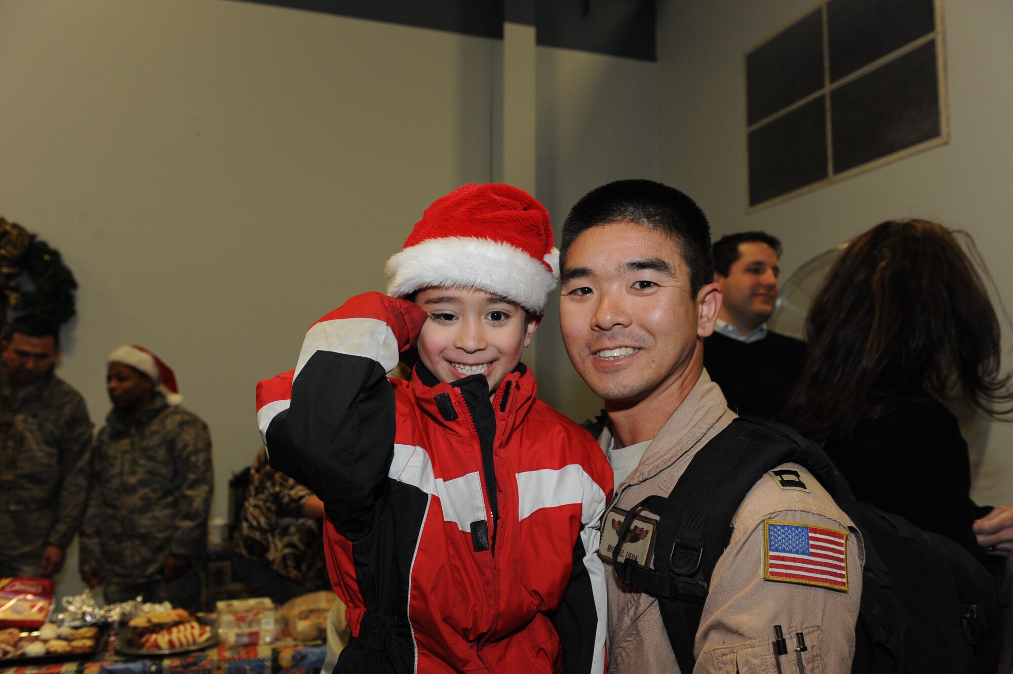 Capt. Michael Ueda, a 61st Airlift Squadron pilot, poses for a photo with his son, Lucas, after his return from his deployment Dec. 25 at Building 430. Nearly 160 Airmen returned home Christmas Day. (U.S. Air Force photo by Senior Airman Ethan Morgan)