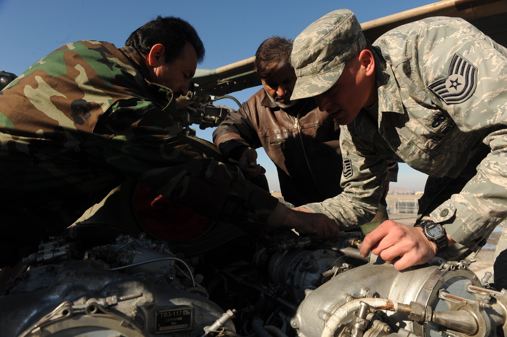 Afghanistan National Army Air Corps Soldiers and Tech. Sgt. Kevin Duffy, 738th Air Expeditionary maintenance advisor, perform routine maintenance on a MI-17 helicopter at Kandahar Airfield, Afghanistan, Jan. 5, 2010. Segeant Duffy is deployed from Joint Base McGuire-Dix-Lakehurst, N.J.  (U.S. Air Force photo by Staff Sgt. Manuel J. Martinez/Released) 