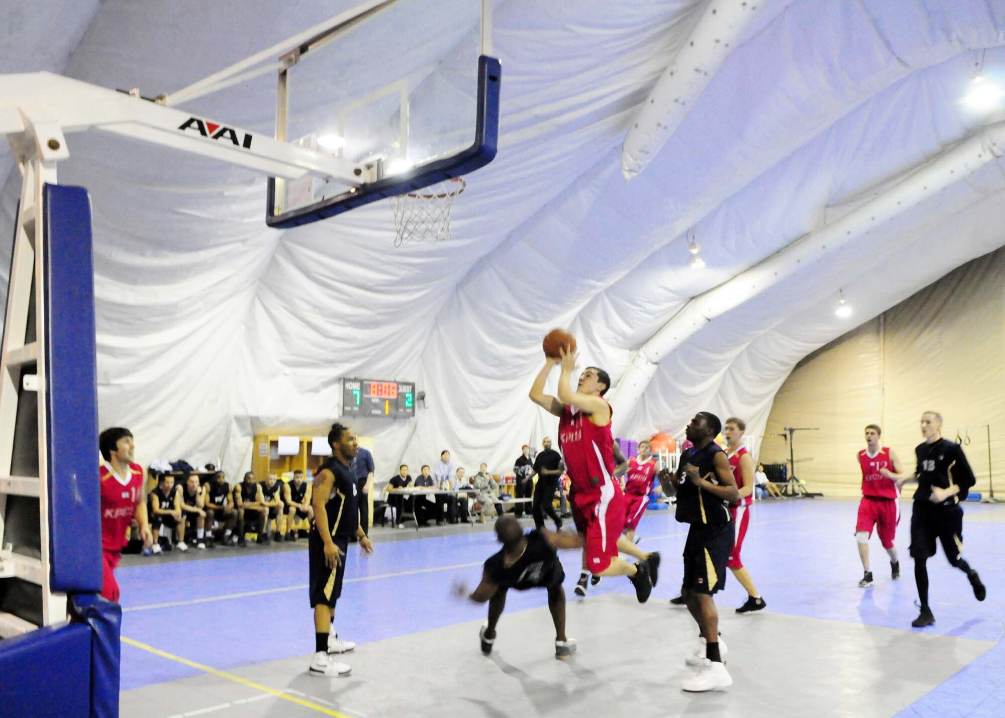 A student from the Kyrgyz Russian Slavic University goes in for a layup against Transit Center at Manas basketball player during a game here Jan. 5. The Transit Center team hosted the local team to build camaraderie amongst Airmen and Kyrgyz countrymen. (U.S. Air Force photo by Senior Airman Nichelle Anderson)