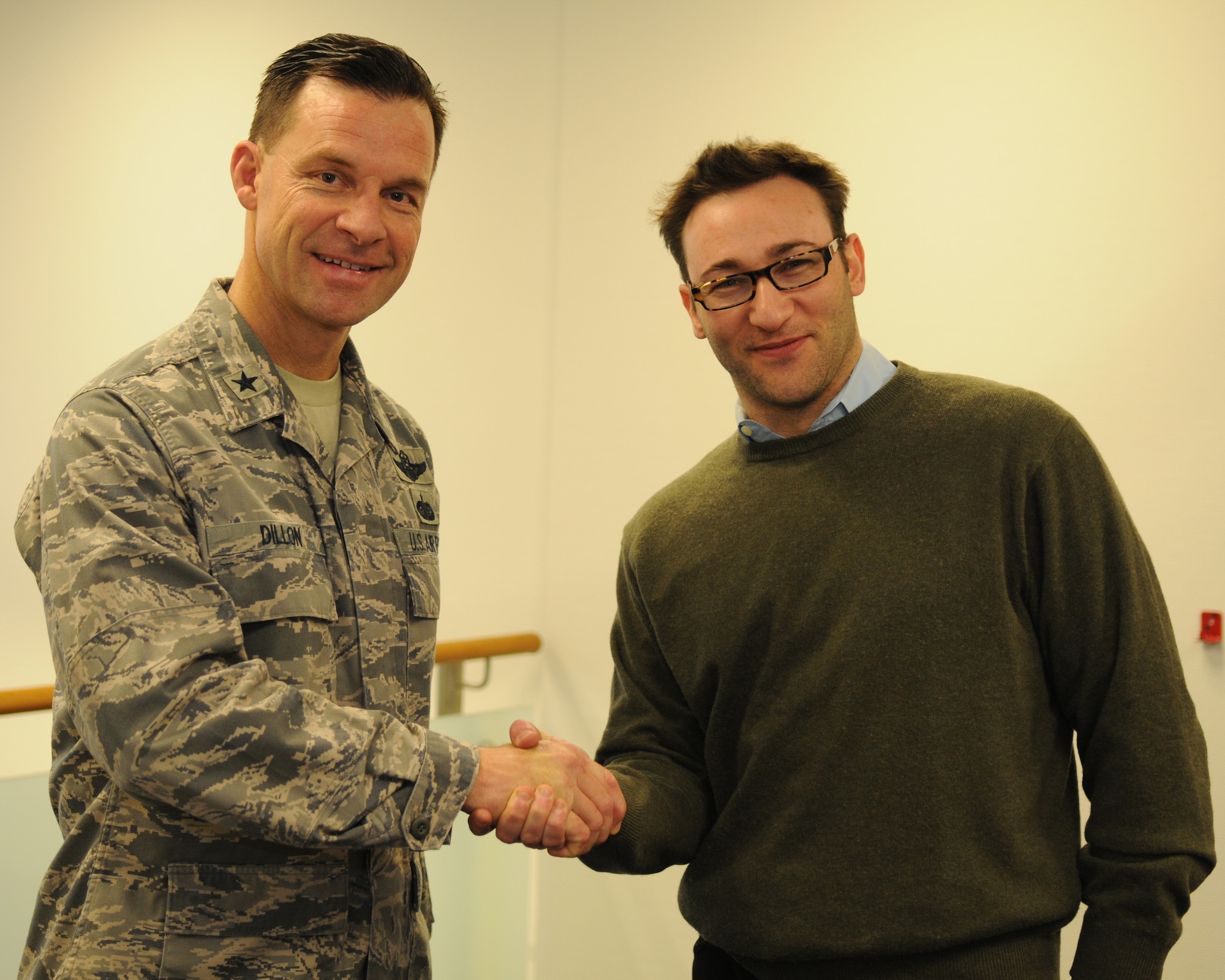 U.S. Air Force Brig. Gen. Mark Dillon, 86th Airlift Wing commander, shakes hands with Simon Sinek, a motivational speaker who spoke to Airmen at Ramstein Air Base, Germany, Jan. 5, 2010. Mr. Sinek stopped to meet and teach Airmen the art of inspiring people. (U.S. Air Force photo by Master Sgt. Quinton T. Burris)