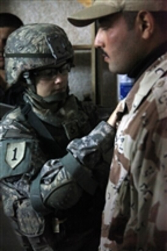 Pfc. Misty Raines, assigned to Charlie Company, 701st Brigade Support Battalion, 4th Brigade Combat Team, 1st Infantry Division, demonstrates the proper application of medical supplies to the Iraqi Army medical staff at Ordnance Park, Tikrit, Iraq, on Dec. 17, 2009.  