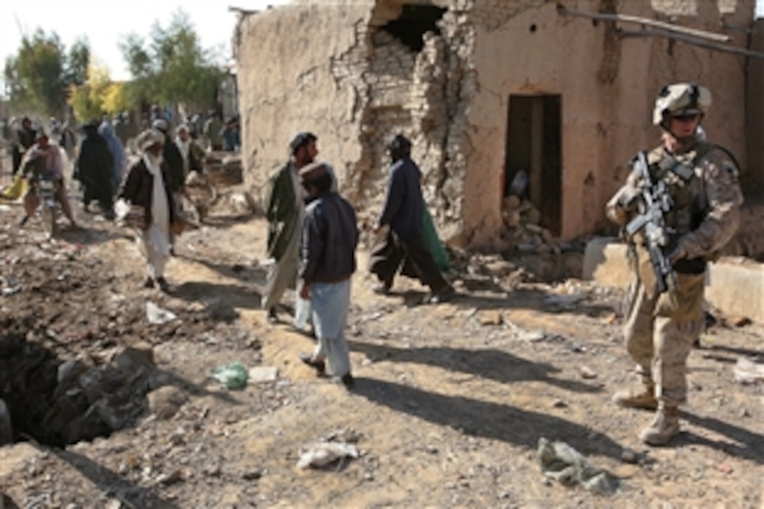 U.S. Marine Corps Cpl. Alex Ivy observes the surrounding area as Afghans work to rebuild their shops in Now Zad, Afghanistan, Dec. 15, 2009. Ivy is a mortar man with Weapons Company, 3rd Battalion, 4th Marine Regiment.