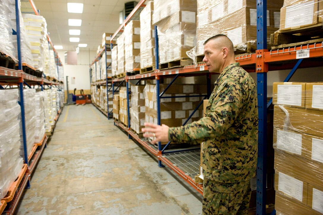 Master Sgt. Timothy Greenleaf, logistics chief, explains the warehousing operations in the bulk storage area of the MCI warehouse at the Washington Navy Yard in Washington, D.C., Jan 6. Textbooks for professional military education are maintained separately in this aisle to allow the warehouse clerks to easily assemble and process multiple books, which are shipped out as part of a series.