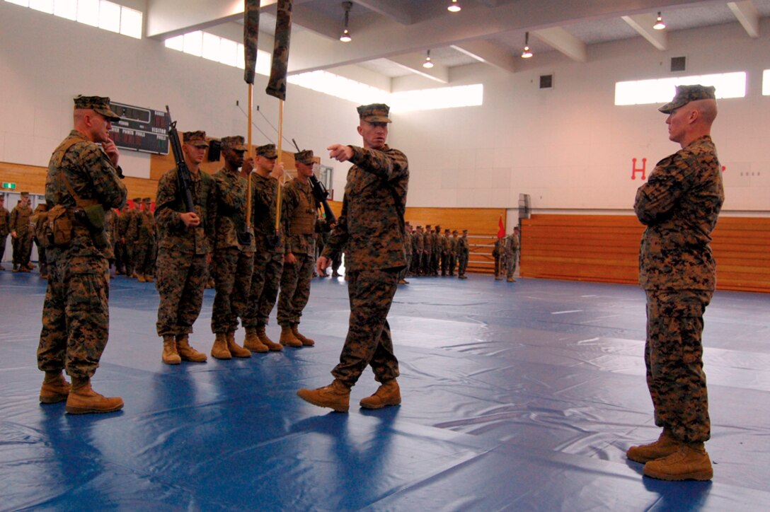 Sgt. Maj. John Ploskonka, outgoing sergeant major for 9th Engineer Support Battalion, 3rd Marine Logistics Group, III Marine Expeditionary Force, center, consults with Sgt. Maj. James Calbough, the battalion's incoming sergeant major, right, about movement of troop elements in Camp Hansen's gym during a Jan. 7 indoor practice for their relief and appointment ceremony. Calbough officially took his place as the 9th ESB sergeant major in a ceremony at Camp Hansen's parade deck Jan. 8.