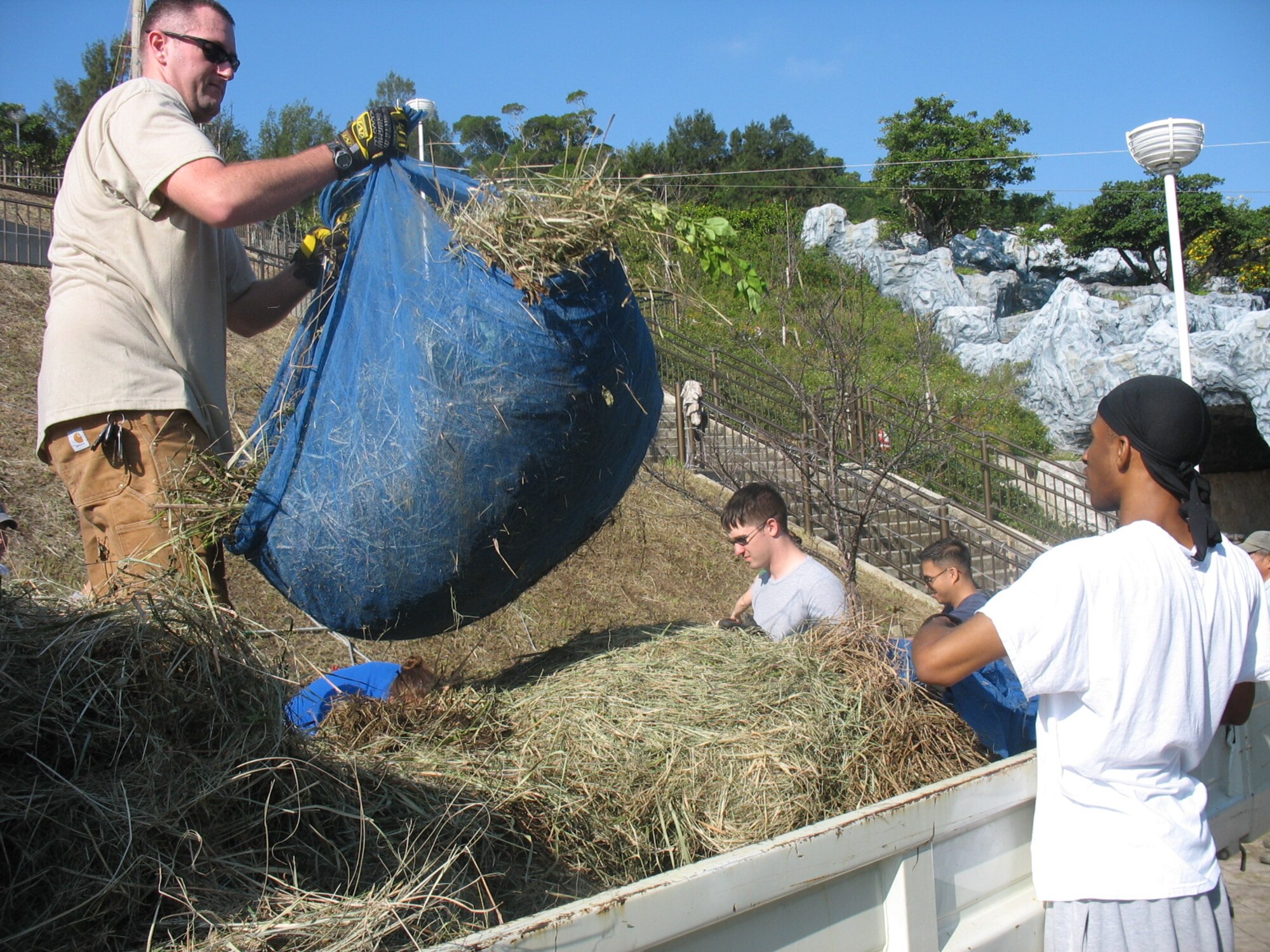 Airman Leadership School volunteers help clean up yard waste at Okinawa Children's Zoo Dec. 12. Hundreds of Kadena residents gave back to their local communities by making donations to orphanages and special needs homes and participating in area clean up activities. (Courtesy photo)