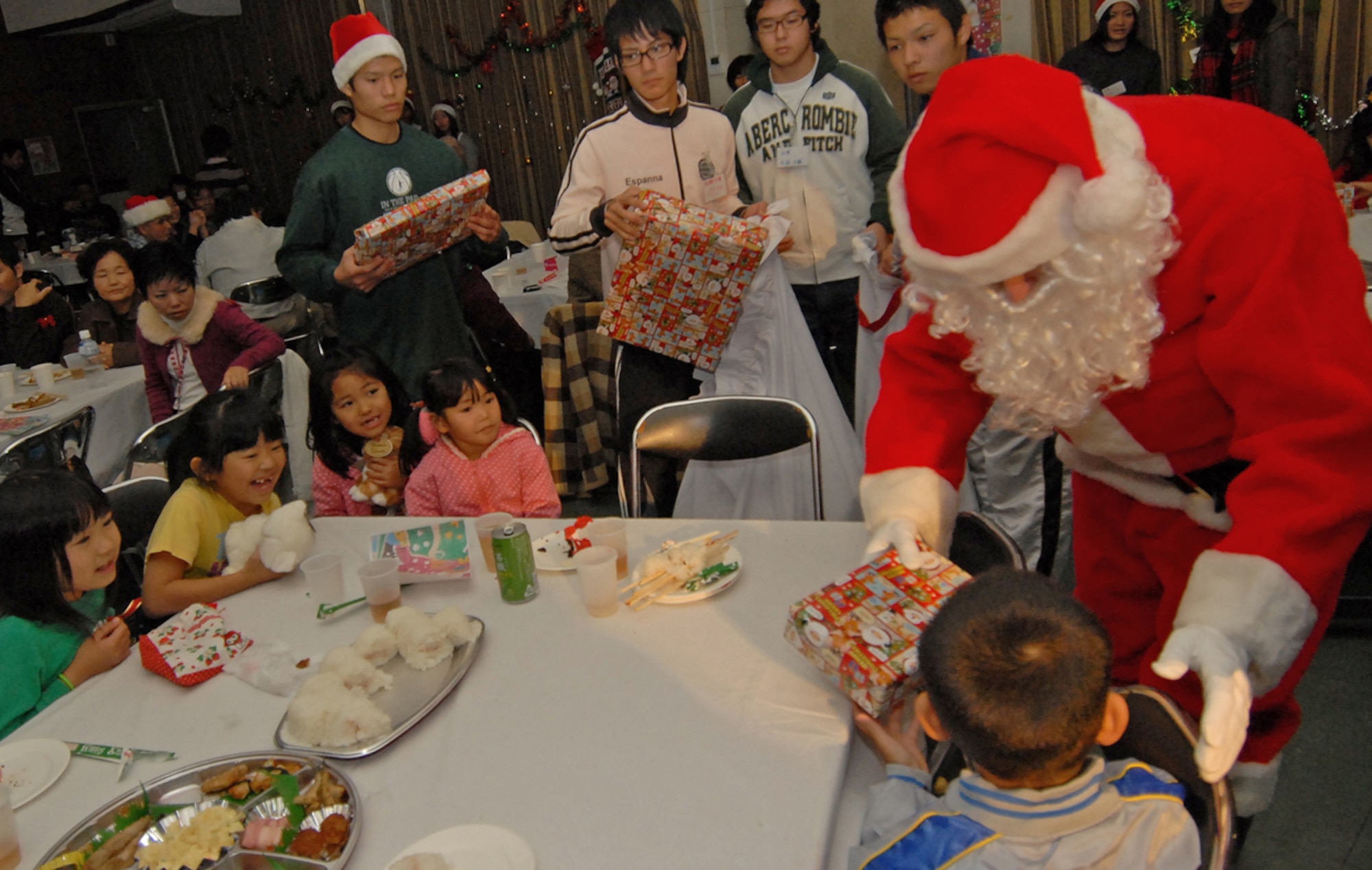 Santa Claus hands out presents donated by Kadena organizations to Okinawan children at the Yomitan Social Welfare Center Dec. 19. Hundreds of Kadena residents gave back to their local communities by making donations to orphanages and special needs homes and participating in area clean up activities. (Air Force/Staff Sgt. Jason Lake)