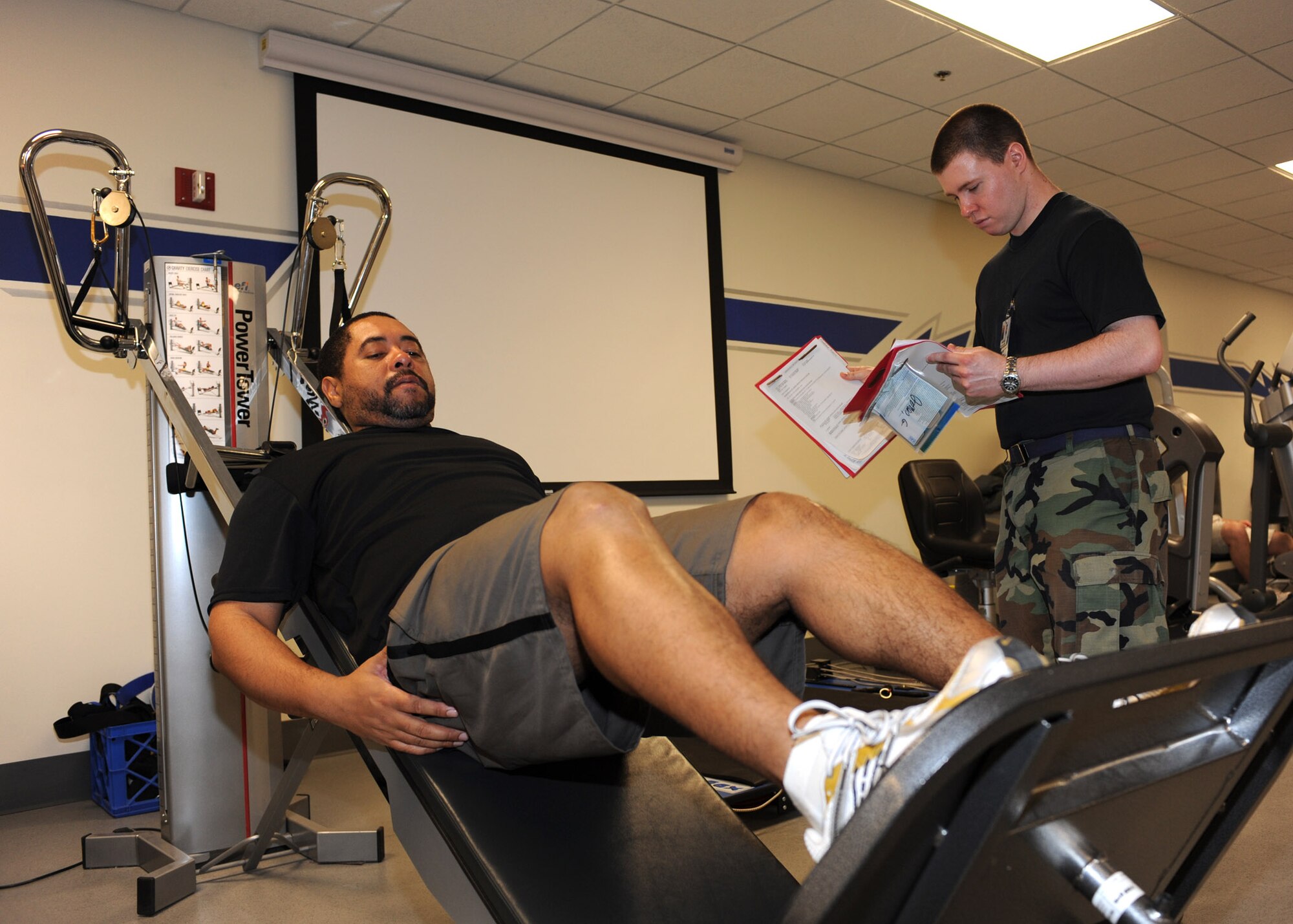 Senior Airman Brian McDougall, a physical therapist technician at the 355th Medical Group, observes Tech. Sgt. Jones Gardner, 355th Civil Engineer Squadron, as he performs a leg press as part of a personalized workout regimen prepared by a physical therapist at the 355th Medical Group Physical Therapy clinic, Jan. 6. The staff at the physical therapy clinic assists more than 100 patients every week, each with a plan of care specifically designed for the individual and their injuries. (U.S. Air Force photo/Airman Jerilyn Quintanilla)


