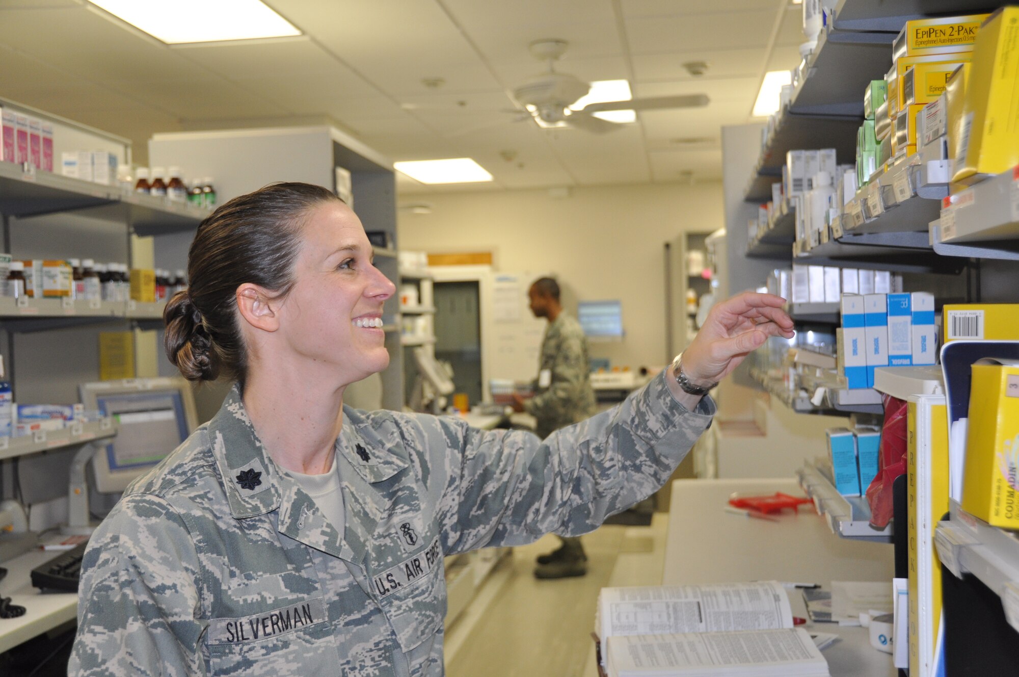Lt. Col. Shari Silverman, 325th Medical Support Squadron commander, assists Airmen with filling prescriptions at the pharmacy.  (U.S. Air Force photo by/Senior Airman Veronica McMahon)