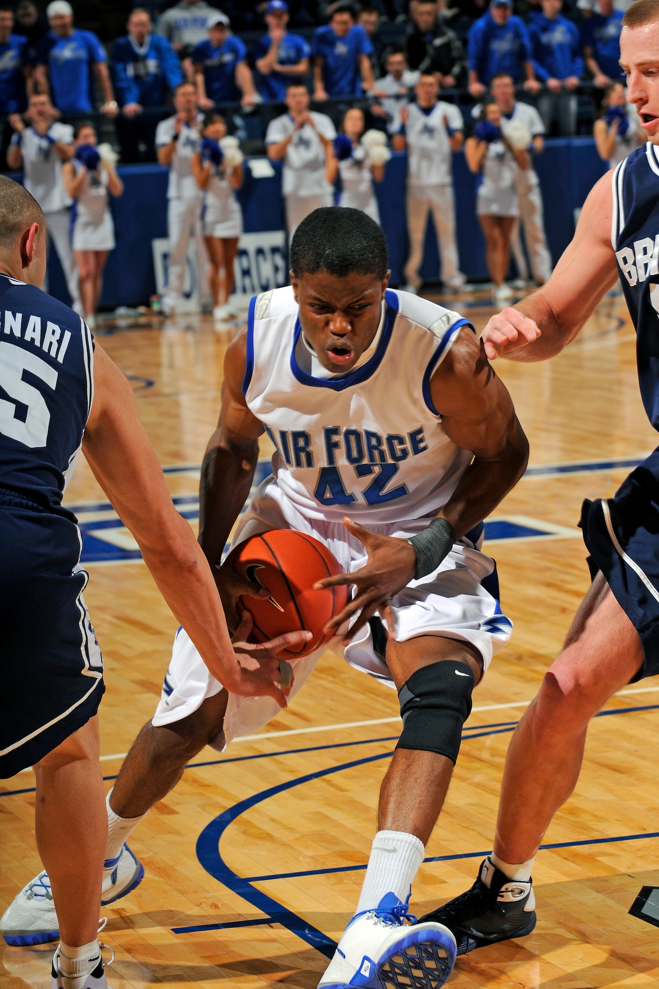 Air Force's Anwar Johnson pushes between BYU's Jonathan Tavernari and another defender during the Falcons-Cougars game at the Air Force Academy's Clune Arena Feb. 3, 2009. The Falcons fell to BYU in the quarterfinal game of the Mountain West Conference Basketball Championships March 12 after advancing to the tournament for the first time in team history. (U.S. Air Force photo/Dave Ahlschwede)
