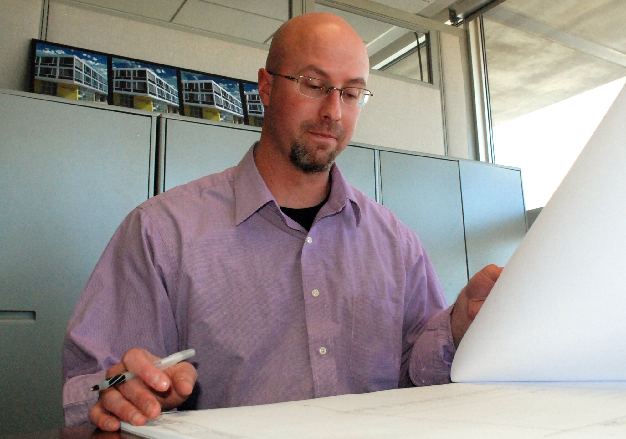 Russell Hume delves into plans for the Cadet Character and Leadership Center, slated for construction beginning in 2011. Mr. Hume, a mechanical engineer with the Air Force Academy's 10th Civil Engineer Squadron, received a 2009 Air Force Energy Conservation Award for his efforts in moving the Academy toward fossil fuel independence by 2015. (U.S. Air Force photo/Ann Patton)