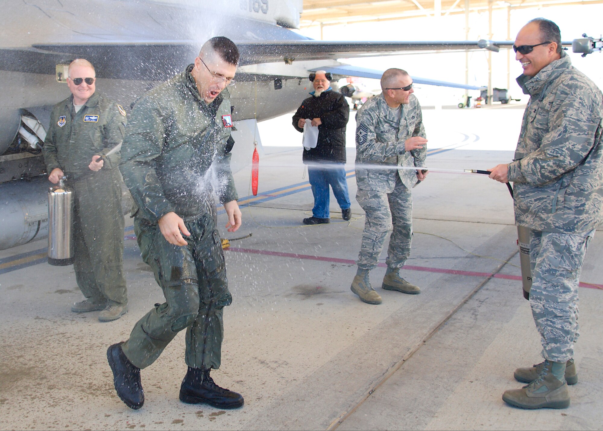Col. Jerry Gandy (left), 95th Air Base Wing commander, and Col. Joe Torres (right), 95th Air Base Wing vice commander, hose down Chief Master Sgt. Eric Jaren, 95th Air Base Wing command chief master sergeant, following his fini-flight Jan. 7. The flight was piloted by Col. William Thornton, 412th Test Wing commander, in an F-16 Fighting Falcon. Chief Jaren will soon leave Edwards to become the command chief master sergeant of Headquarters Air Force Materiel Command. (Air Force photo/Mike Cassidy)