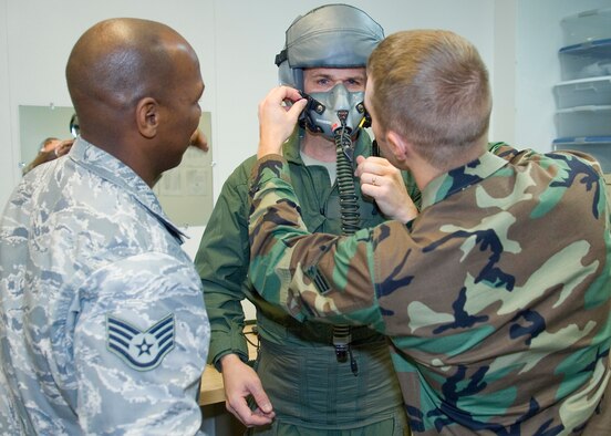 Chief Master Sgt. Eric Jaren, 95th Air Base Wing command chief master sergeant, gets fit with an oxygen mask by Senior Airman Travis Barron and Staff Sgt. Ed Eberhart, 412th Operations Support Squadron Life Support Equipment Section Jan. 6, in preparation for his fini-flight Jan. 7. Chief Jaren has served as the command chief master sergeant of the 95th ABW since August 2008 and is leaving to helm the top enlisted rank for Headquarters Air Force Materiel Command, located in Wright-Patterson Air Force Base, Ohio. (Air Force photo/Mike Cassidy)