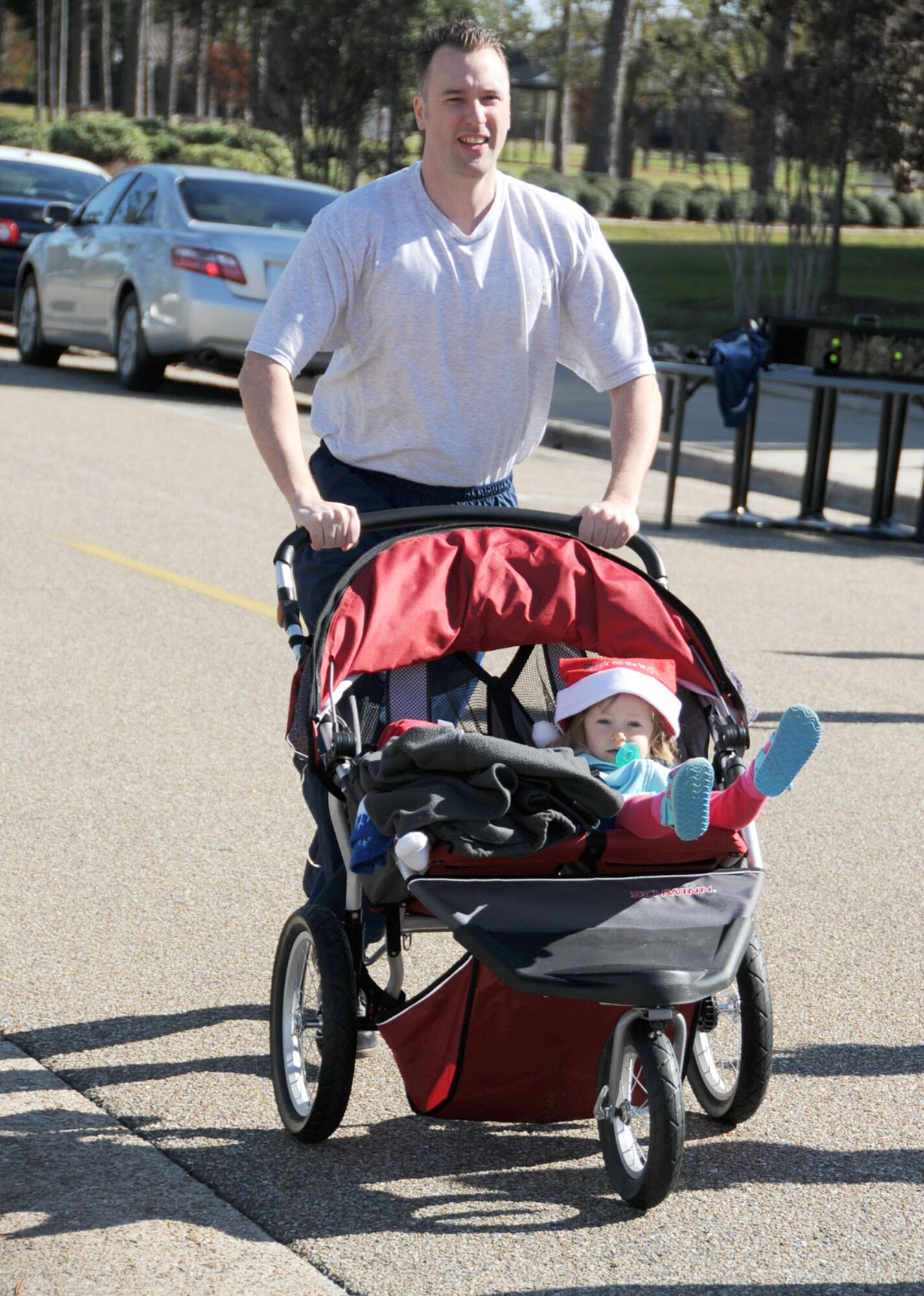 Tech. Sgt. Robert Carroll, 336th Training Squadron, participates in the Jingle Bell 5-kilometer fun run Dec. 16 with his daughters, 9-month old Samantha and 2-year-old Alexandra.  Times weren’t recorded for the run, but Sergeant Carroll’s wife, Laura, was the first woman to finish.  The first man to cross the finish line was Senior Airman Emanuel Balderas, 81st Medical Suport Squadron.  (U.S. Air Force photo by Kemberly Groue)