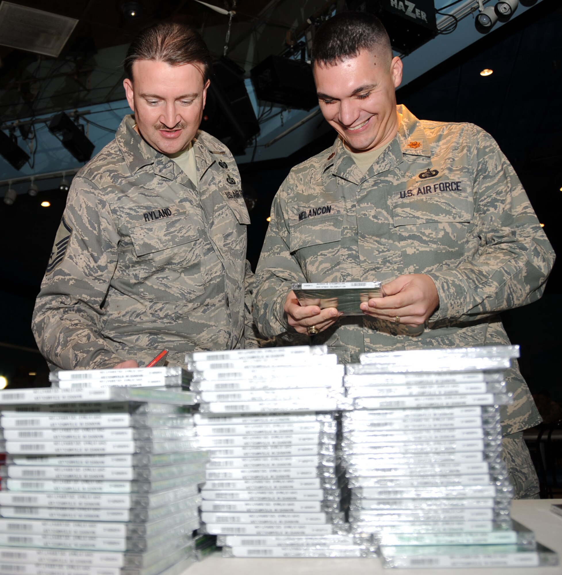 Master Sgt. Lorne Ryland, 81st Training Wing, and Maj. Keith Melancon, 338th TRS, go through stacks of free CDs given away during the burger burn.   (U.S. Air Force photo by Kemberly Groue)