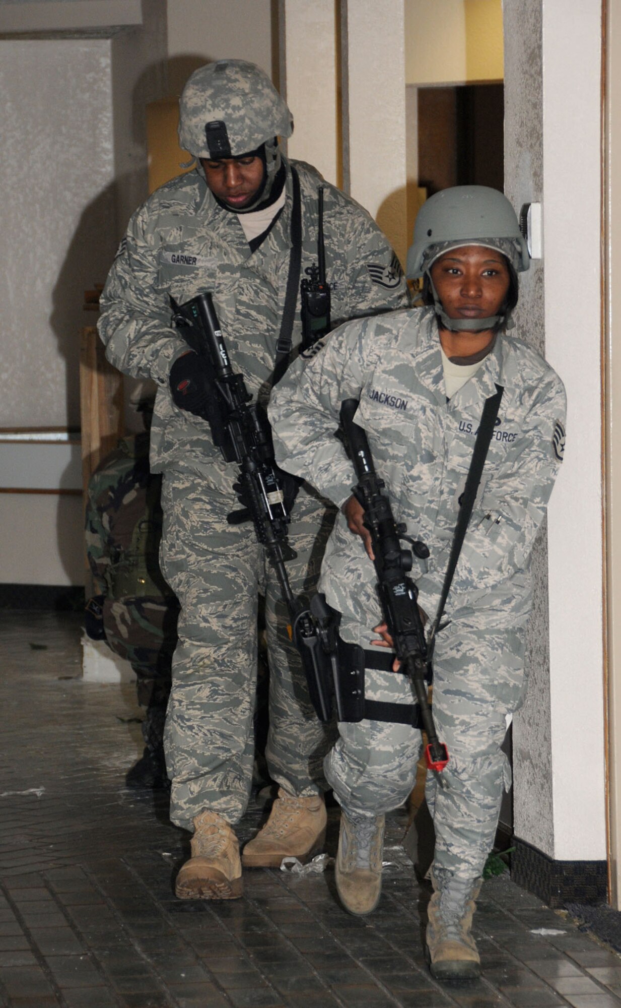 Staff Sgts. Jonathan Garner, left, and Eulonda Jackson move down a Muse Manor hallway during a Dec. 17 training exercise .  (U.S. Air Force photo by Kemberly Groue)
