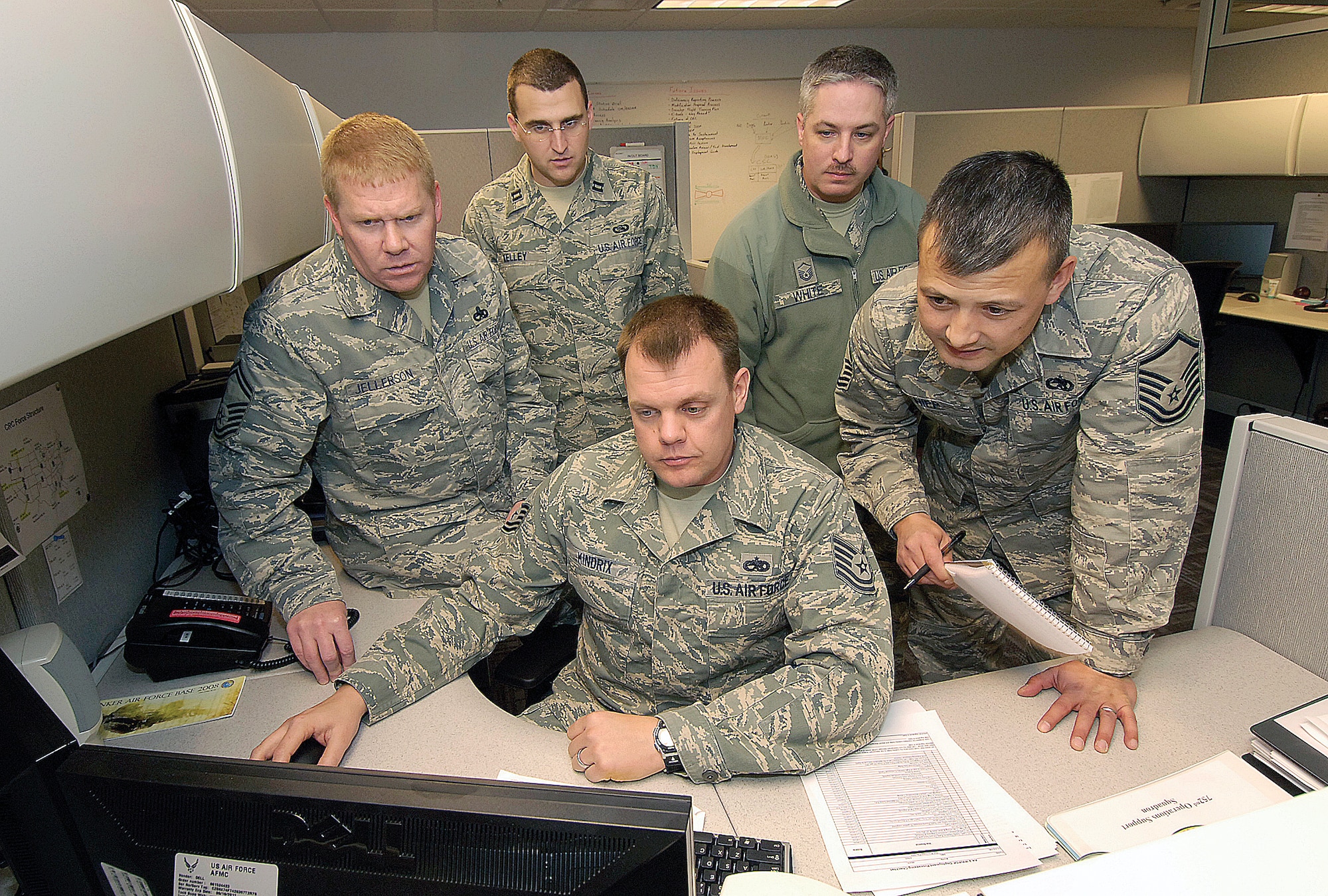 From their newly renovated Tinker home in Bldg. 285, members of the 752nd Operations Support Squadron prepare for a staff assistance visit to Luke Air Force Base, Ariz. Clockwise from front are; Tech Sgt. Wayne Kindrix, Senior Master Sgt. Marcus Jellerson, Capt. Richard Kelley, Master Sgt. Tim White, and Master Sgt. Robert Hipp. (Air Force photo by Margo Wright)