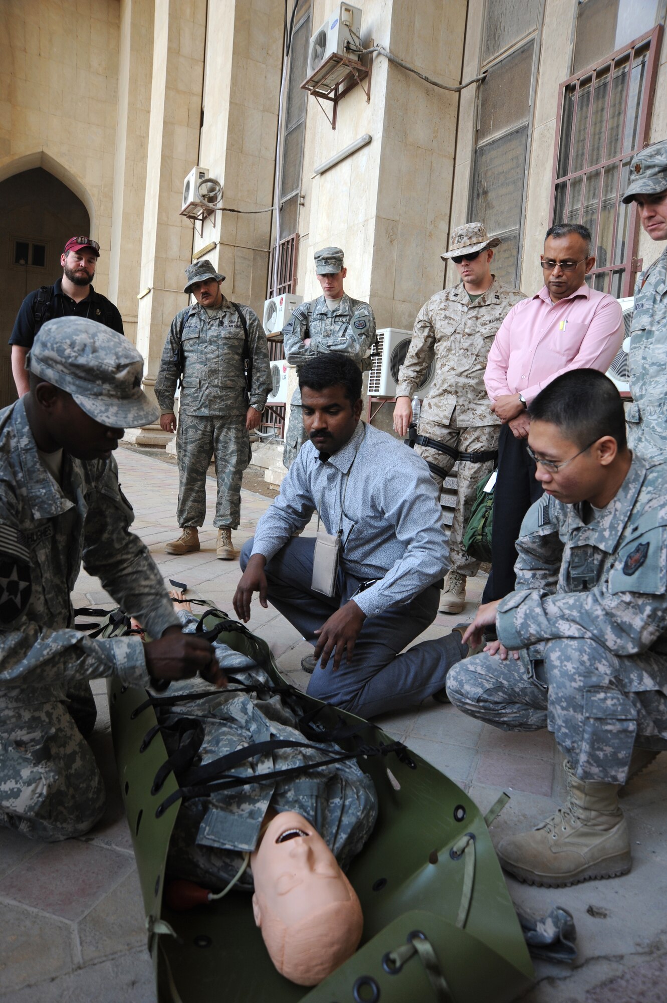 Army Sgt. Donell Hughes (left), demonstrates to students how to properly place an individual on a litter during a combat lifesaver training course Dec. 29, 2009, at Baghdad, Iraq. The students were given opportunities to practice using a litter during the exercise portion of the course. Sergeant Hughes is a U.S. Forces-Iraq, Deputy Commanding General-Advising and Training Health Affairs combat medic. (U.S. Air Force photo/Master Sgt. Trish Bunting)
