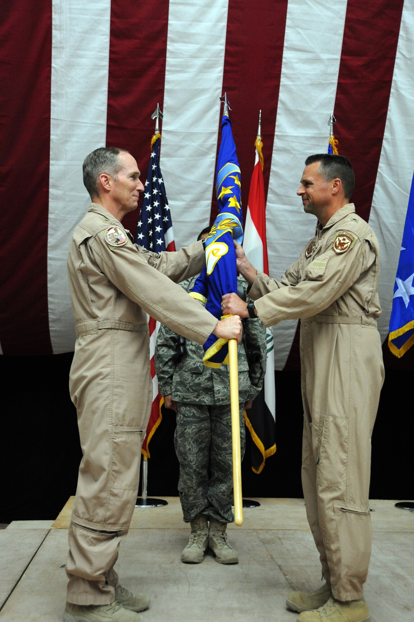 Air Force Lt. Gen. Mike Hostage (left), commander of the U.S. Air Forces Central Command, hands the guidon to Brig. Gen. Scott Hanson, incoming commander of the 321st Air Expeditionary Wing during the change of command ceremony in Al Faw Palace on Victory Base Complex, Baghdad, Jan. 7, 2010. The mission of the 321st AEW is to train and advise the Iraqi air force in order to advance the foundational airpower capabilities of Iraqi Airmen. (U.S. Air Force photo/Master Sgt. Trish Bunting/Released)