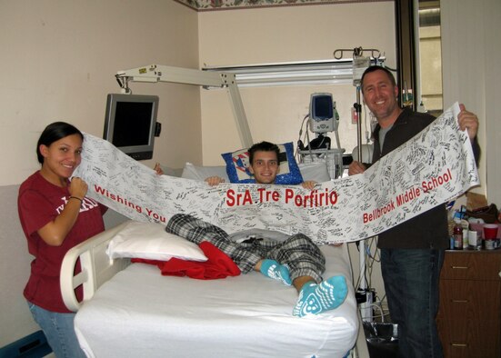 Senior Airman Tre Porfirio (center), Airman First Class Ahja Nock, and Lt.
Col. Rick Johns, hold a banner of get well wishes from Bellbrook (Ohio)
Middle School students Dec. 29, 2009 at Walter Reed Army Medical Center.  Porfirio is recovering after a groundbreaking Thanksgiving Day surgery when doctors
removed his damaged pancreas, harvested islet cells and transplanted them
into his liver.  A communications technician with the 88th Communications Squadron, Senior Airman Porfirio was shot in the back by an insurgent while
deployed with an Army unit to Afghanistan.  Nock is a mental health technician with the 88th Medical Operations Squadron and Johns is commander of the 88th
Communications Squadron.  All three Airmen are assigned to Wright-Patterson
Air Force Base, Ohio. (courtesy photo)
