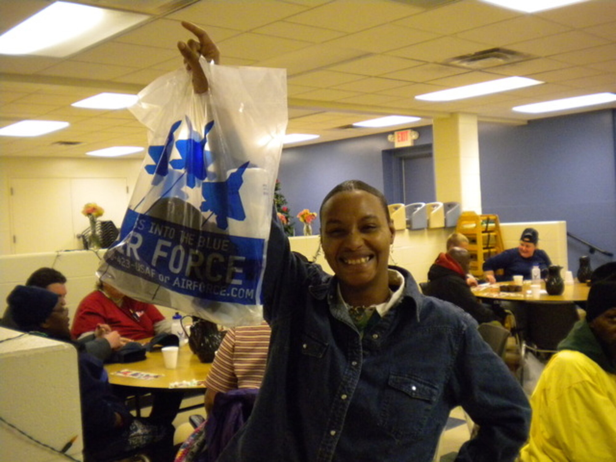 A Ministry with Community member with her winnings from a bingo game run by the 339th Recruiting Squadron and their families. Members of the 339th RCS and their families spent an afternoon with the shelter running a bingo game and giving players hot chocolate. (U.S. Air Force photo/Denise McMillen)