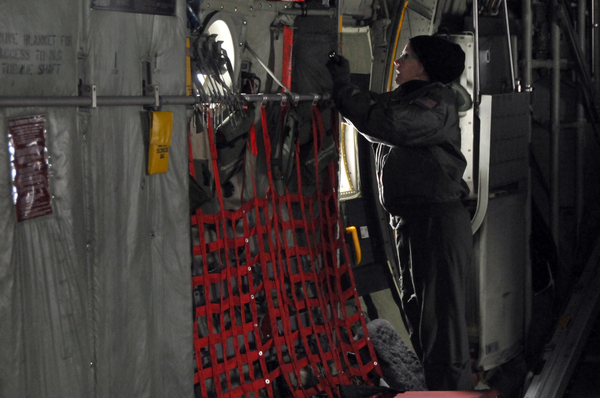 Staff Sgt. Rebekah Rock, Flight Engineer with the 130th Airlift Wing, Yeager Airbase Charleston, W.Va. preflights a C-130H3 Hercules, visually inspecting the aircraft for leaks or damage, Tuesday, Nov. 5, 2010. Due to the snowstorm, aircrew readied the plane for a training flight a day early. The West Virginia Air National guard remained 100% mission capable in spite of the biggest accumulation of snow in the past ten years. (U.S. Air Force photo by William Hinamon/Released)