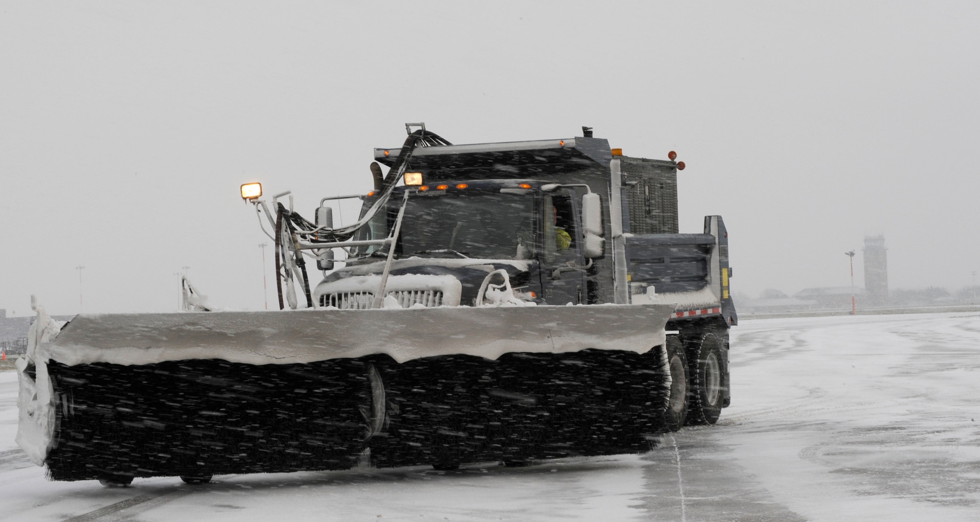 RAF MILDENHALL, England – Richard Austin, 100th Civil Engineer Squadron, drives a snow sweeper to keep the runway clear for incoming and outgoing aircraft Jan. 7.  When there is snow, keeping the runway clear is first priority for snow removal teams.  (U.S. Air Force photo/Staff Sgt. Christopher L. Ingersoll)