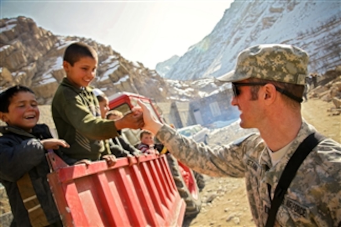 U.S. Air Force Capt. John Stamm thumb wrestles with Afghan children during a visit to the Dara district of the Panjshir province of Afghanistan on Jan. 3, 2010.  Stamm is a public affairs officer assigned to the Panjshir Provincial Reconstruction Team.  