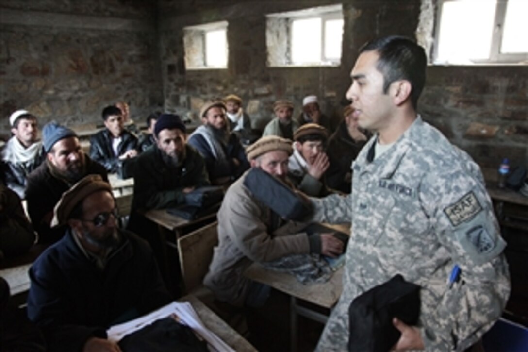 U.S. Air Force Staff Sgt. Abraham Jara hands out first aid kits to Afghan locals during a first aid class at a school in the Dara district of Panjshir province, Afghanistan, on Jan. 3, 2010.  Jara is a medic assigned to the Panjshir Provincial Reconstruction Team.  