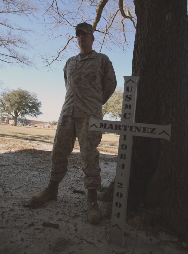 Lance Cpl. Andrew Johnson a motor transportation operator with Combat Logistics Company 46, Combat Logistics Battalion 46, Combat Logistics Regiment 27 (Forward), stands near a monument to Pfc. Oscar A. Martinez, who was killed by a rocket attack in 2004, at Camp Al Taqaddum in Iraq’s Al Anbar province. The unit decided to carry the monument home to give to the Martinez family.