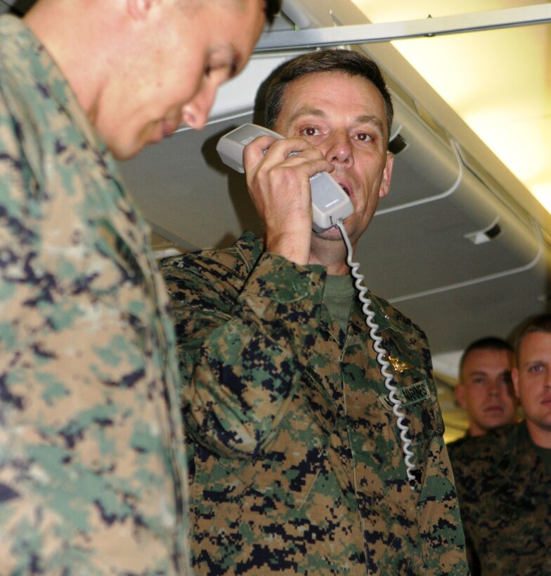 Col. Paul L. Damren (center), 31st Marine Expeditionary Unit (MEU) Commanding Officer, welcomes the Marines and sailors of Battalion Landing Team 2nd Battalion, 7th Marines (BLT 2/7), to Okinawa using an airplane intercom system Jan. 8. The Marines and sailors of BLT 2/7 will serve as the ground combat element (GCE) of the 31st MEU during its upcoming Spring Patrol of the Asia-Pacific region. According to Lt. Col. John Reed, the battalion's Commanding Officer, this is the first time since the Korean War the battalion has served as an amphibious assault force and the first time in the battalion's history it has served as a BLT.