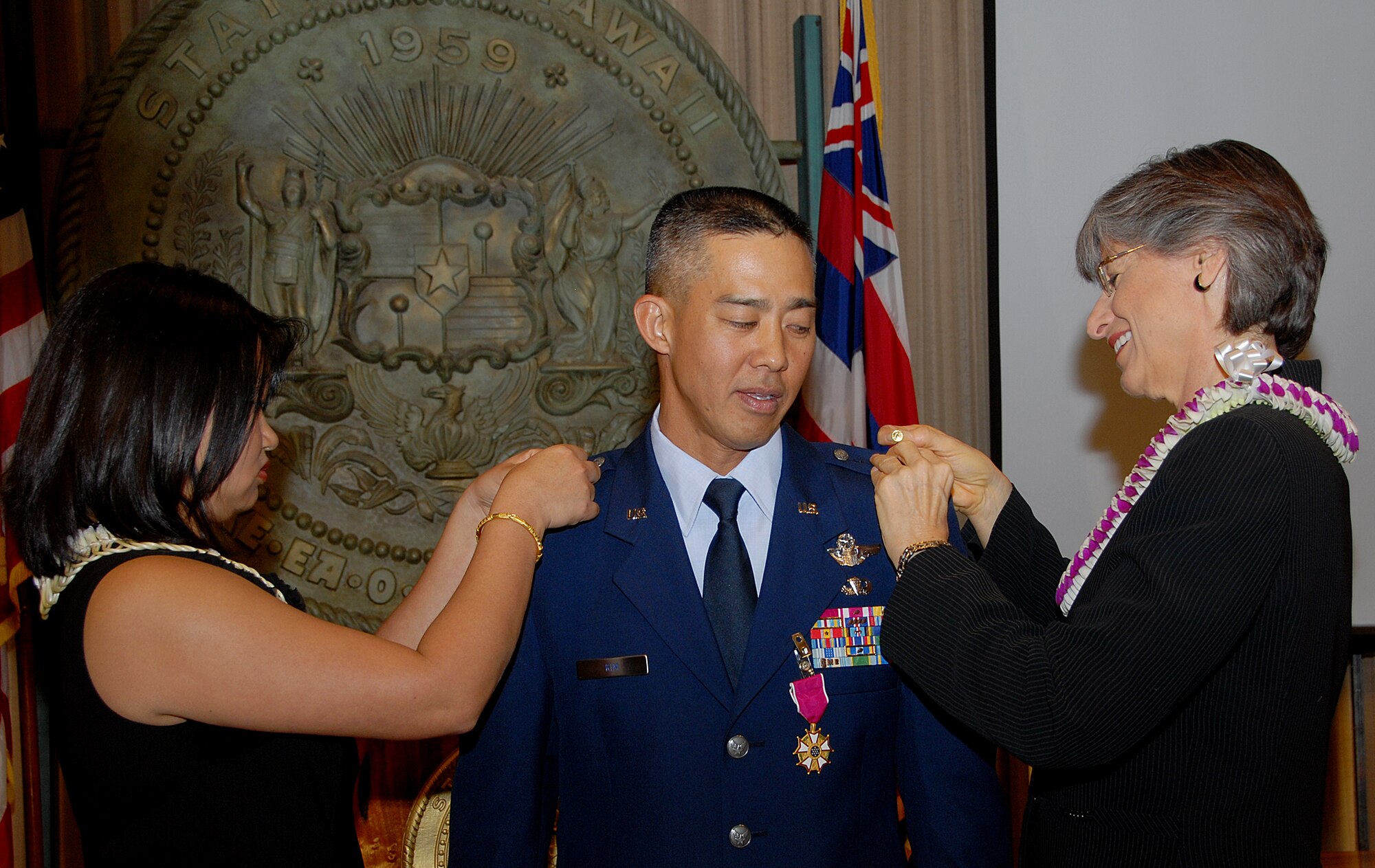 Newly promoted Brig. Gen. Joseph K. Kim looks on as Hawaii, Gov. Linda Lingle pins on the brig. gen. star. Brig. Gen. Kim's wife, Kim, finishes the job by pinning the star on his right shoulder during the promotion ceremony held at the state Capitol, Jan. 8. Brig. Gen. Kim was officially named the 154th Wing Commander during the promotion ceremony. (U.S. Air Force photo/Tech. Sgt. Betty J. Squatrito-Martin)