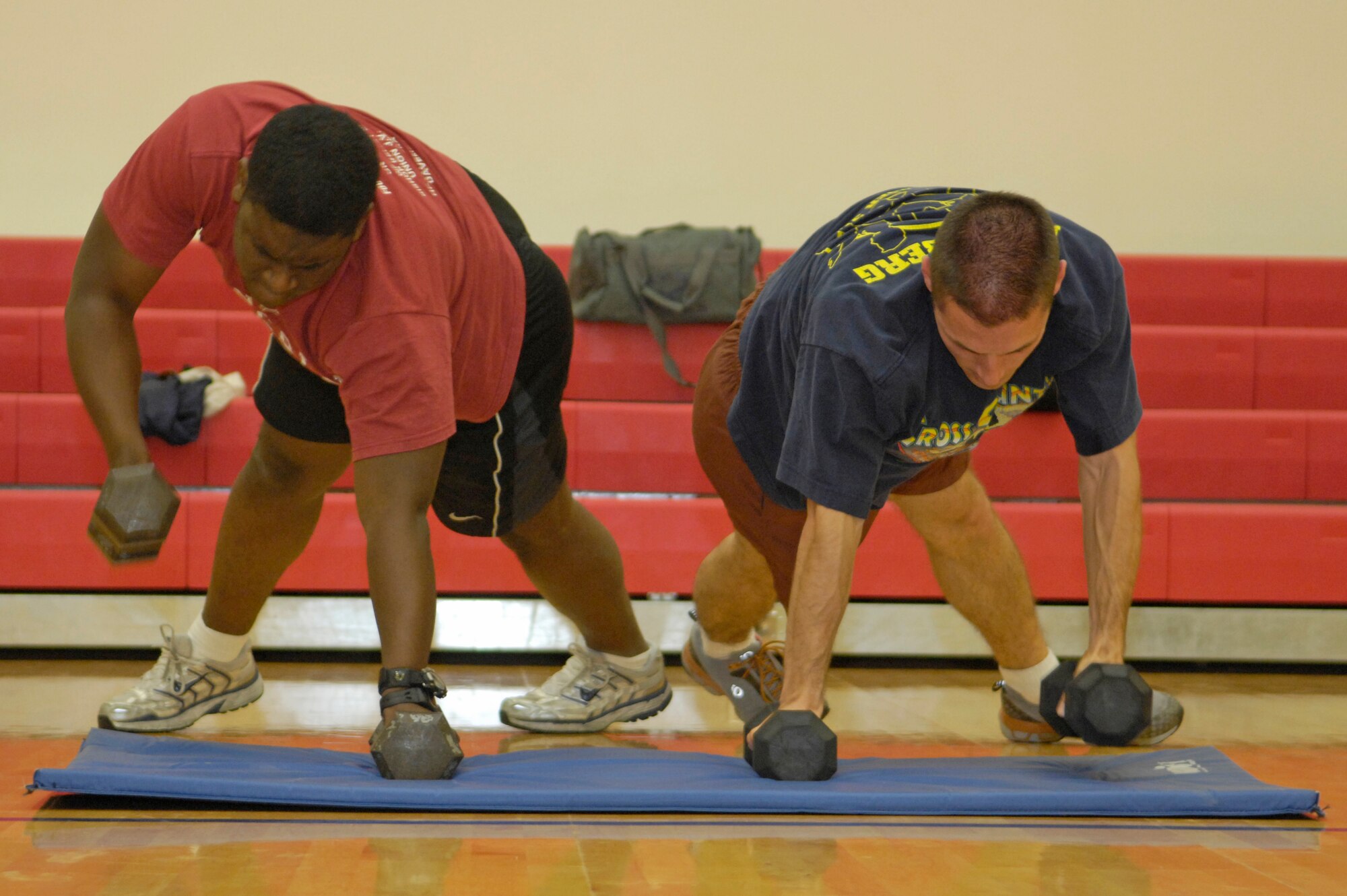 VANDENBERG AIR FORCE BASE, Calif. -- Working hard alongside each other, Sidney Wilkinson and Jason Christopher, both from the Space and Missiles Systems Center located at Los Angeles AFB, Calif., do push-up rolls with weights here during the Hardcore 30-Minute Workout here Wednesday, Jan. 6, 2010. The workout program is provided at the base fitness center at lunchtime from noon to 12:30 p.m. (U.S. Air Force photo/Airman 1st Class Andrew Lee)
 
 
 
