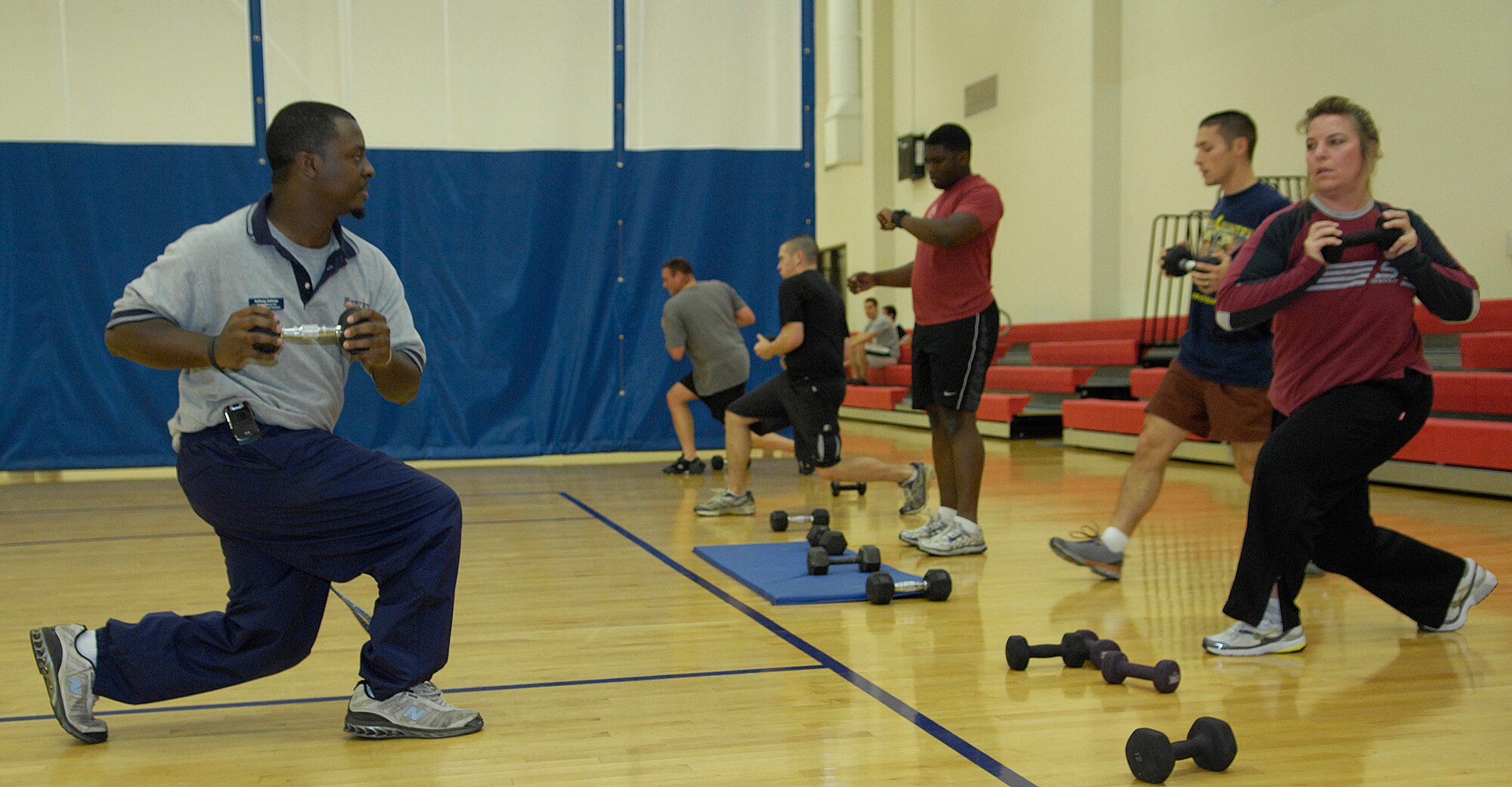 VANDENBERG AIR FORCE BASE, Calif. - Helping out the Hardcore 30-Minute Workout attendees, Anthony Sullivan, a sports fitness aid for the base fitness center, shows how to properly do lunges and twists here Wednesday, Jan. 6, 2010. The workout program is provided at the base fitness center at lunchtime from noon to 12:30 p.m. (U.S. Air Force photo/Airman 1st Class Andrew Lee)

 