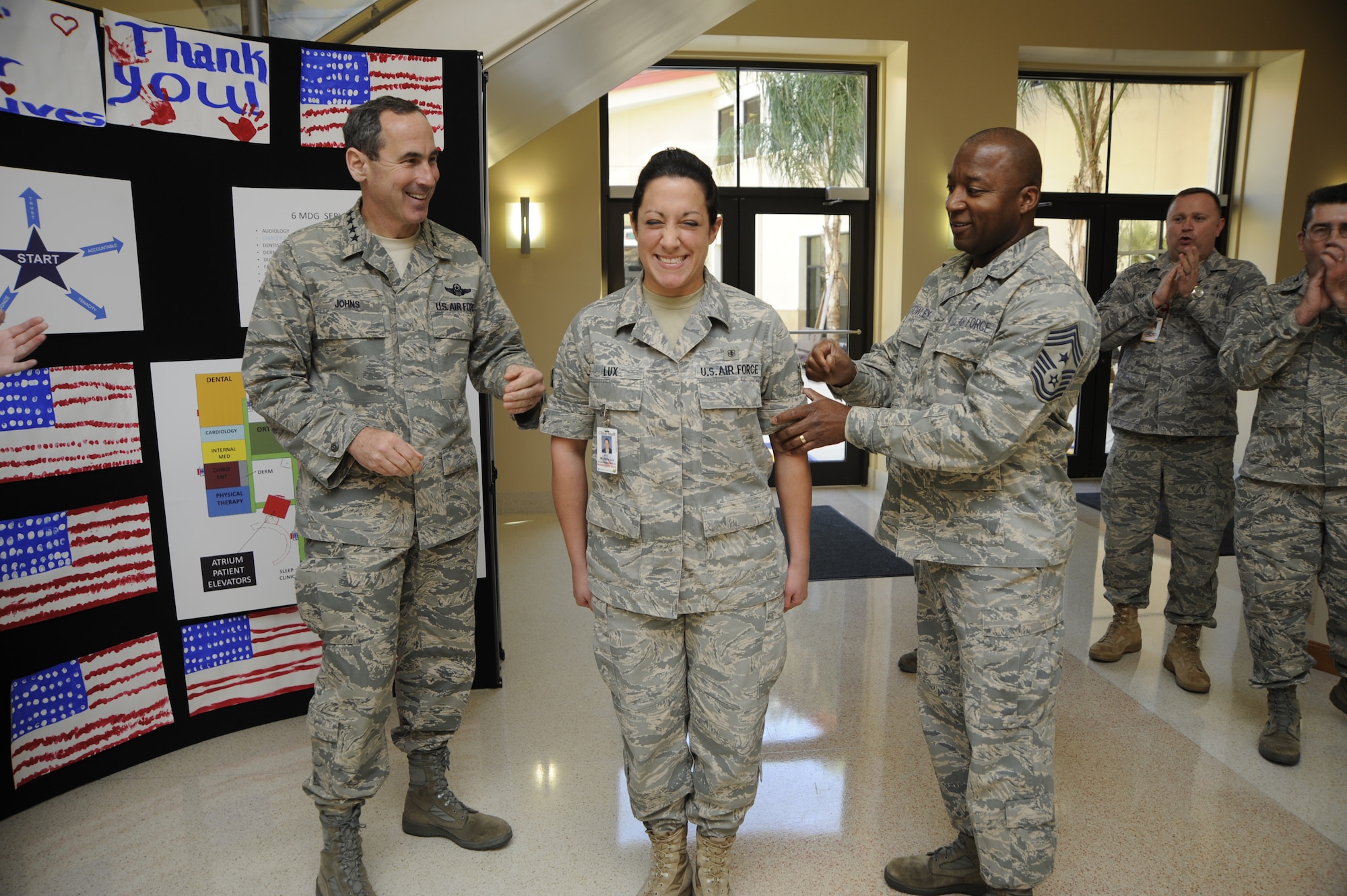General Raymond E. Johns, Air Mobility Command, commander, and Chief Master Sgt. Derrick Crowley, 6th Air Mobility Wing, command Chief, tack on Airman 1st Class Michelle Lux, 6th Medical Group with Senior Airman Below The Zone Stripes Jan. 6, 2010, at MacDill Air Force Base, Fla. Senior Airman BTZ promotes an E-3 to E-4 six months earlier than normal and is only given to the most outstanding Airmen. (US Air Force Photo By: Senior Airman Angela Ruiz)(Released)