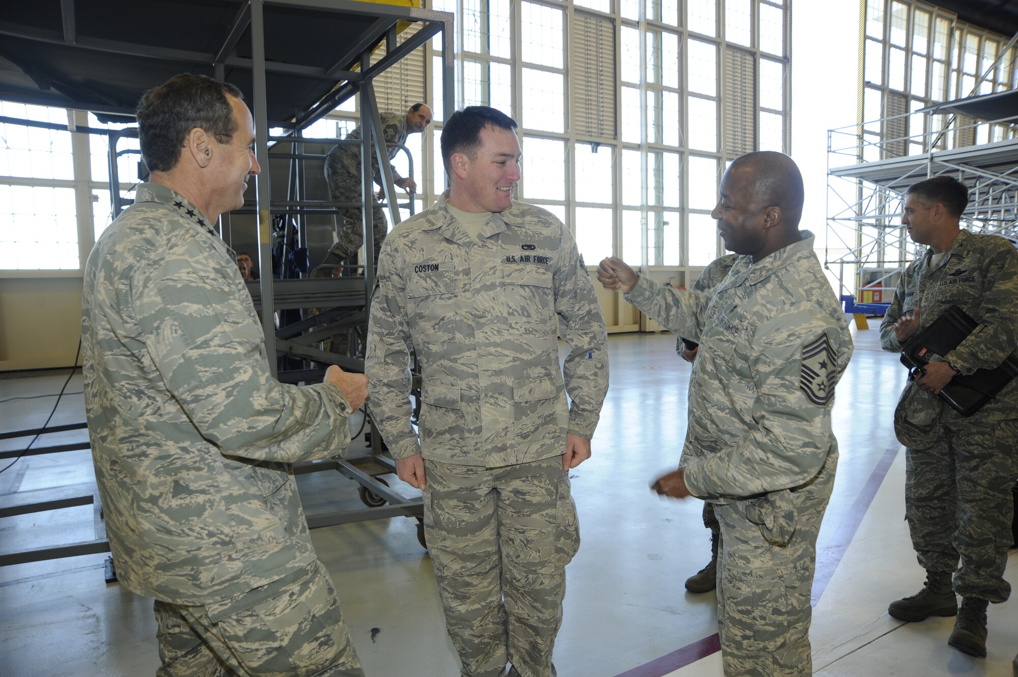 Airman 1st Class Alexander Coston, 6th Maintenance Squadron, gets his Senior Airman Below The Zone promotion stripes Jan. 6, 2010, from Gen. Raymond E. Johns, Air Mobility Command commander and Chief Master Sgt. Derrick Crowley, 6th Air Mobility Wing command Chief, at MacDill Air Force Base, Fla. Senior Airman BTZ promotes an E-3 to E-4 six months earlier than normal and is only given to the most outstanding Airmen.  (US Air Force Photo By: Senior Airman Angela Ruiz)(Released)