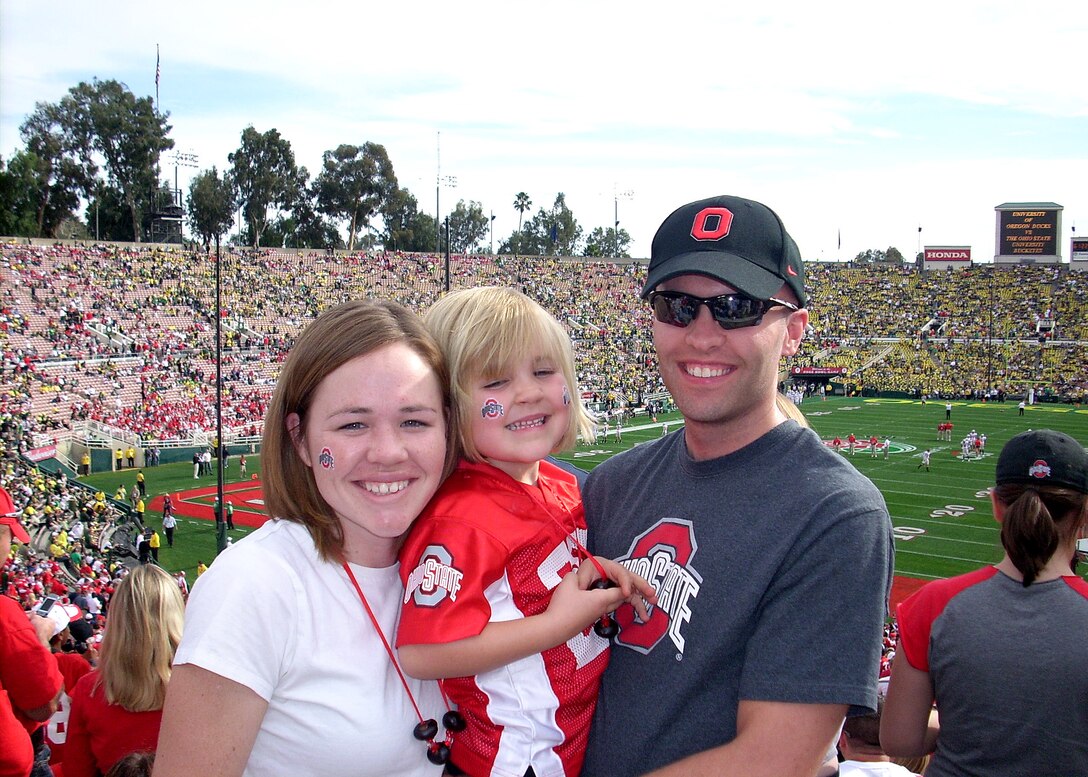 Capt. Andrew Peterson (right), Contracting Officer with the Military Satellite Communications Systems Wing, with his wife Becca, and daughter Alex, are all smiles with the Buckeye win of the Rose Bowl Game, Jan. 1. Captain Peterson and Capt. Kevin Mauersberg, Spacelift Range Acquisition Manager with the Launch and Range Systems Wing, both OSU alumni, enjoyed the opportunity to celebrate the New Year with thousands of other Buckeyes fans at the Rose Bowl Game, Pasadena, Calif., due to the generous gift of tickets from an anonymous donor.(Photo by Capt. Kevin Mauersberg)
