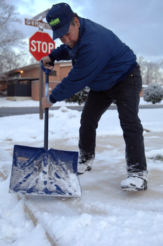 Jose Hernandez, lawn and landscaping contractor, shovels the sidewalk around officer housing Jan. 8 on Joint Base Andrews. The early morning snowfall was the first of the year and brought approximately one to two inches of snow to the area. (U.S. Air Force photo by Staff Sgt Melissa Stonecipher) 