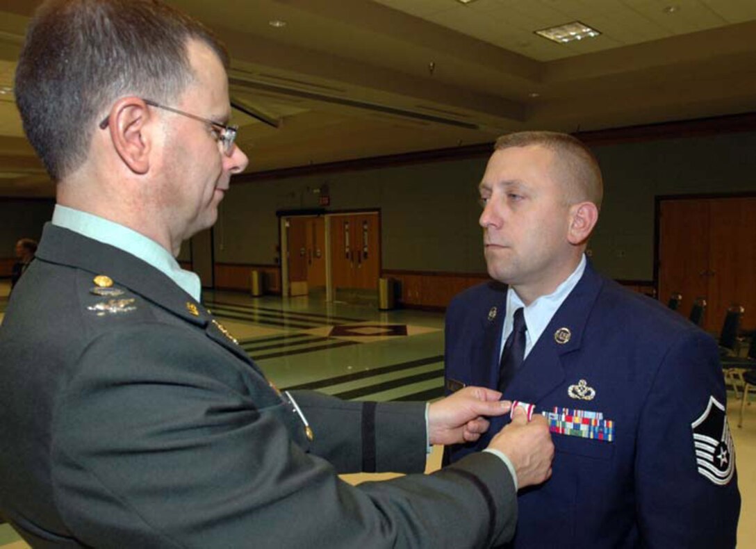 INDIANAPOLIS -- Master Sgt. Kevin Stath receives the Defense Meritorious Service Medal from Col. Mark Rutkowski, director of personnel force innovation at the Defense Finance and Acounting Servce in Indianapolis. Sergeant Stath is a structural craftsman with the 434th Civil Engineer Squadron, and currently on an active duty tour with PFI. (U.S. Army photo by Master Sgt. Craig Pickett)