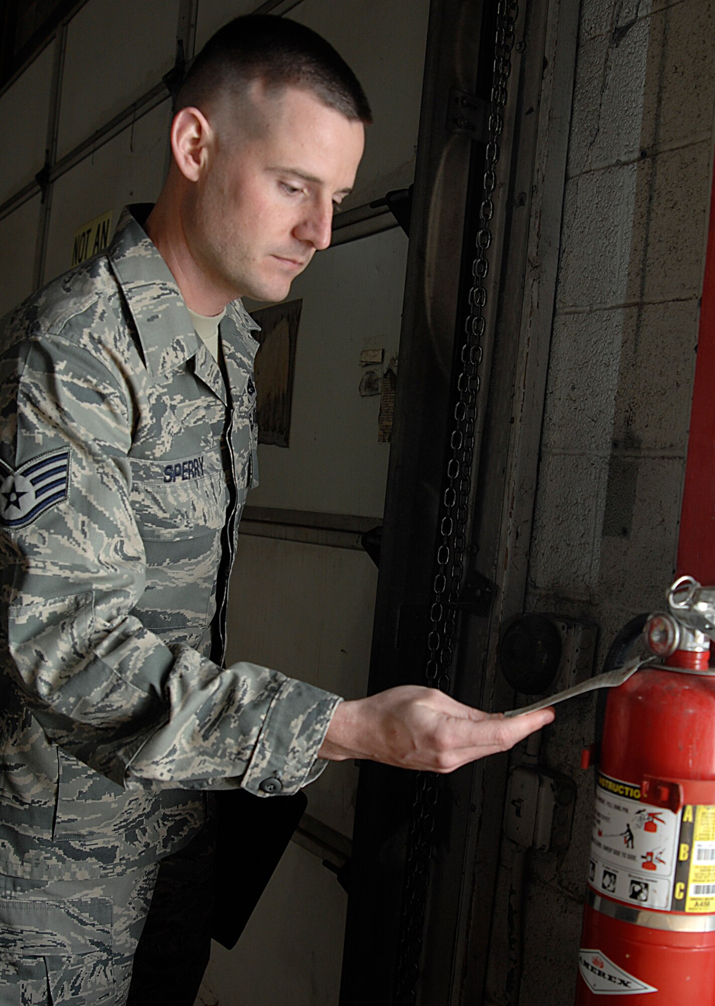 Staff Sgt. Daniel Sperry checks the inspection tag of a fire extinguisher, Jan.  5, 2009, at McConnell Air Force Base, Kan. The Orange, Calif., native is a safety technician for the 22nd Air Refueling Wing Safety office. (U.S. Air Force photo/Senior Airman Jessica Lockoski) 