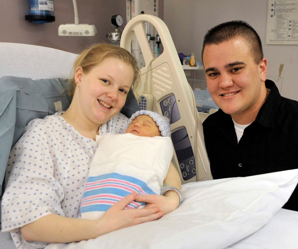 Connie, left, new born baby Audrey, center, and Senior Airman Robert Stroh, 89th Communications Squadron radio operator, right, pose for a photo Saturday for being the family with the first New Years baby born in Malcolm Grow Medical Center’s maternal child unit. Capt. Nicole Chappell, 779th Surgical Operations Squadron obstetrician and gynecologist, and her medical team, delivered Audrey on New Year’s Day. (U.S. Air Force photo/ Staff Sgt. Renae Kleckner)