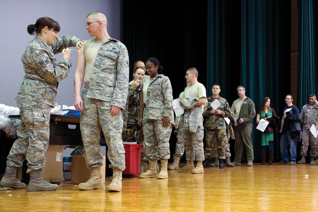 Team Andrews members wait in line to receive their H1N1 shot or nasal spray Wednesday in the Reel Time Theater. More than 800 servicemembers and civilians were inoculated during one of two mass immunizations held at the theater. The H1N1 flu vaccine is required for all servicemembers and available to all beneficiaries and Department of Defense civilians. The vaccine will continue to be offered at the immunizations clinic at Malcolm Grow Medical Center 8 a.m. to 3:30 p.m. Monday through Thursday and 9 a.m. to 3:30 p.m. Friday. (U.S. Air Force photo/ Staff Sgt. Alex Saltekoff)