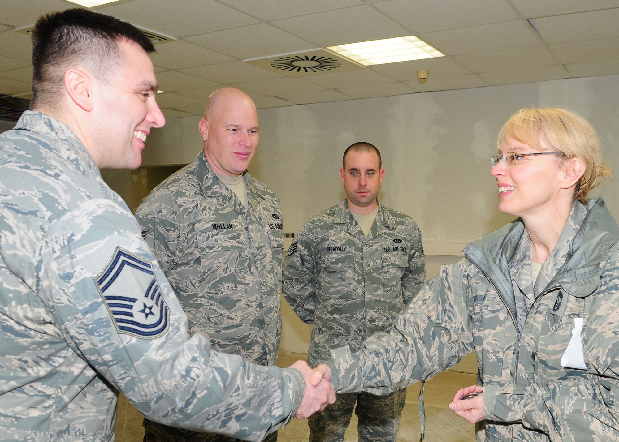 SPANGDAHLEM AIR BASE, Germany -- Senior Master Sgt. John Lysaght, 52nd Equipment Maintenance Squadron, along with Tech. Sgt Brian Whelan and Staff Sgt. Casey Treadway, both of the 52nd Civil Engineer Squadron, receive coins from Chief Master Sgt. Pamela Derrow, U.S. Air Forces in Europe command chief, for their work Jan. 8 at the former Jet Blast flight kitchen.  The transformation of the Jet Blast flight kitchen will be complete in February providing a new recreational dining lounge with close proximity to the flightline. (U.S. Air Force photo/Staff Sgt. Heather M. Norris)