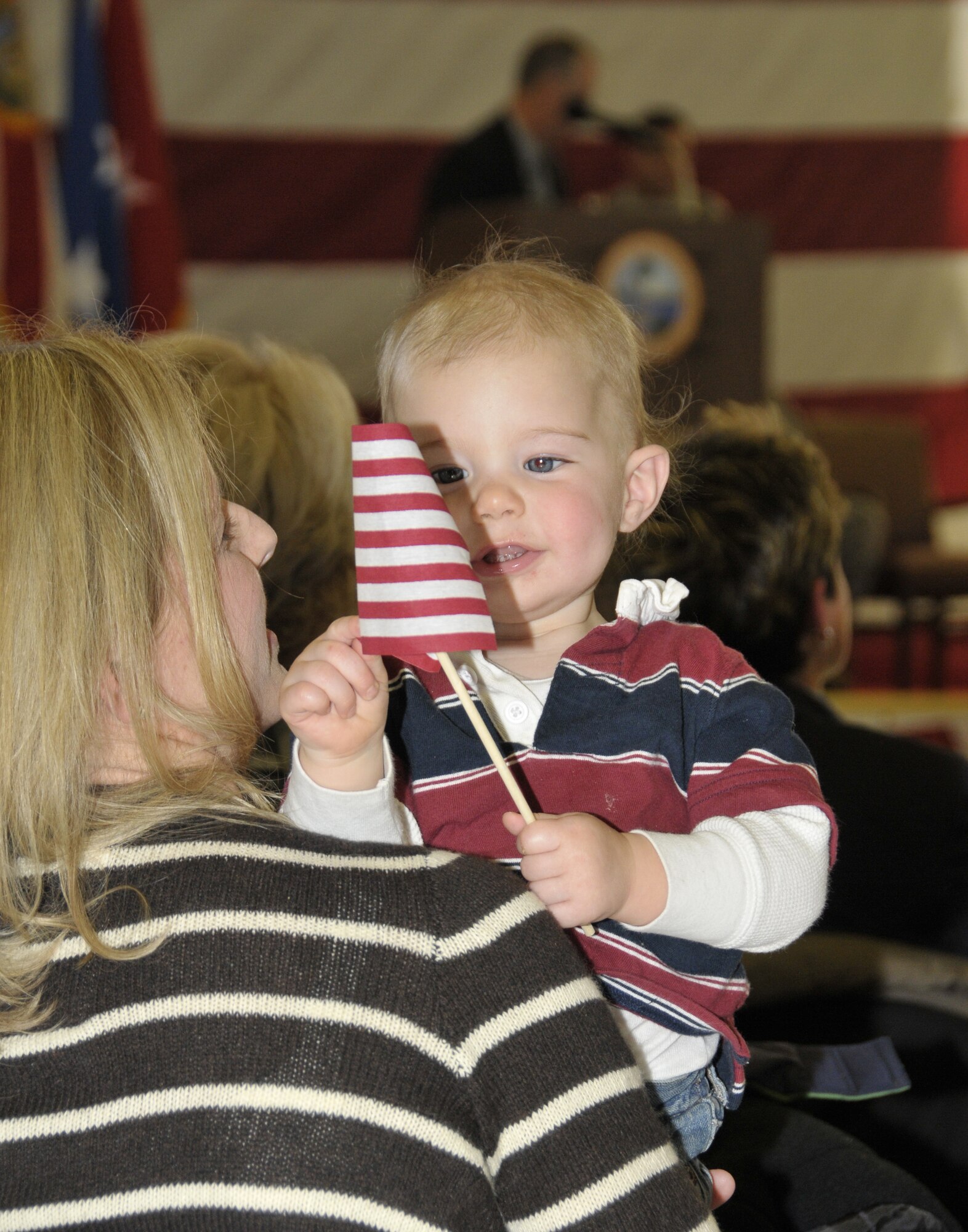 Cinnamon Bitzer, wife of SSgt. Clinton Bitzer, squad leader, held her son Lane, during the Thursday Pre-deployment ceremony. (U.S. Air Force photo by Lisa Norman)
