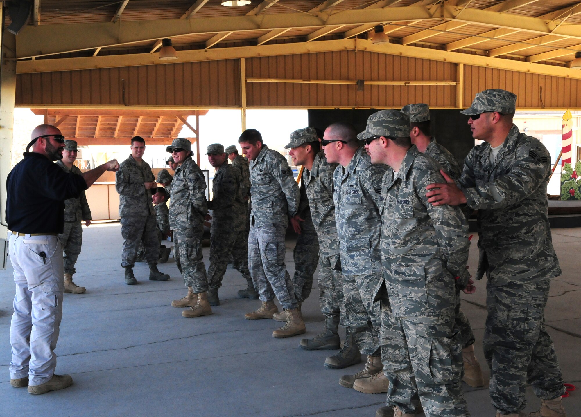 SOUTHWEST ASIA -- Jeff Jones (left); 386th Expeditionary Security Forces Squadron security forces trainer, demonstrates how to search a restrained individual Jan. 8, 2010 at an air base in Southwest Asia. The training is conducted on a quarterly basis to give incoming personnel the basics of force protection techniques. (U.S. Air Force photo by Staff Sgt. Lakisha A. Croley/Released)