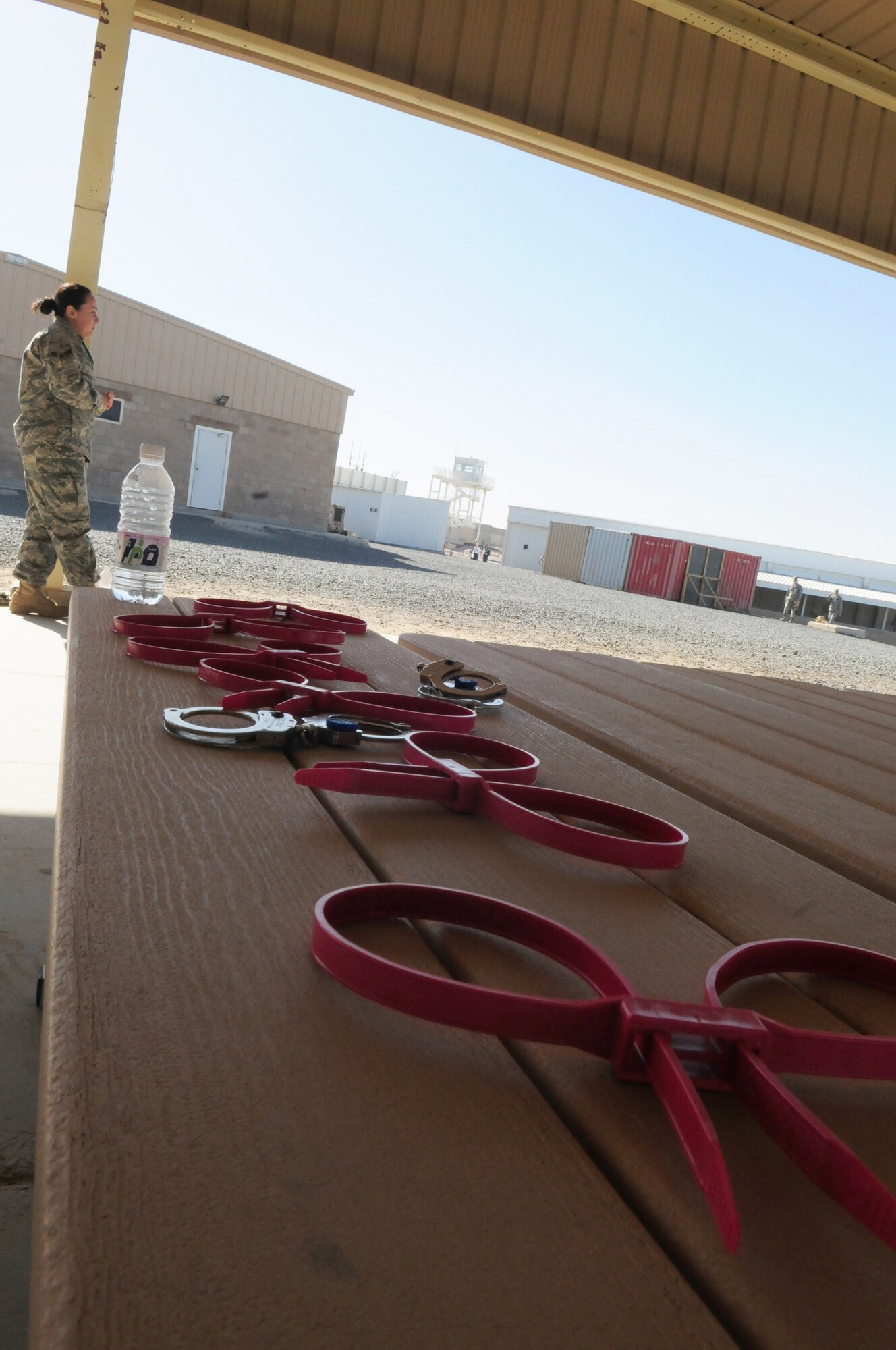 SOUTHWEST ASIA -- U.S. Air Force Airman 1st Class Toni Cooper, 386th Expeditionary Security Forces Squadron force protection flight, watches fellow Airmen practice handcuffing techniques on personnel during a force protection training session Jan. 8, 2010 at an air base in Southwest Asia. The training is conducted on a quarterly basis to give incoming personnel the basics of force protection techniques. Airman Cooper is deployed from Nellis Air Force Base, Nev. (U.S. Air Force photo by Staff Sgt. Lakisha A. Croley/Released)
