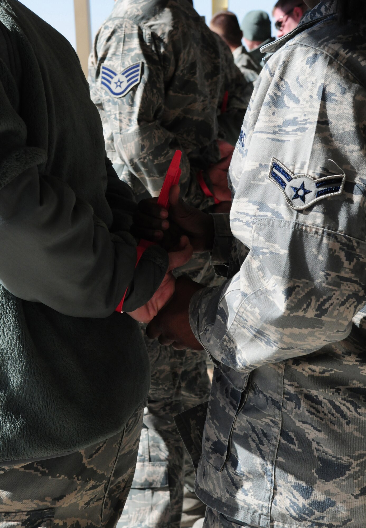 SOUTHWEST ASIA -- Members of the 386th Air Expeditionary Wing practice handcuffing restrained personnel Jan. 8, 2010 during a force protection training session at an air base in Southwest Asia. The training is conducted on a quarterly basis to give incoming personnel the basics of force protection techniques. (U.S. Air Force photo by Staff Sgt. Lakisha A. Croley/Released)

