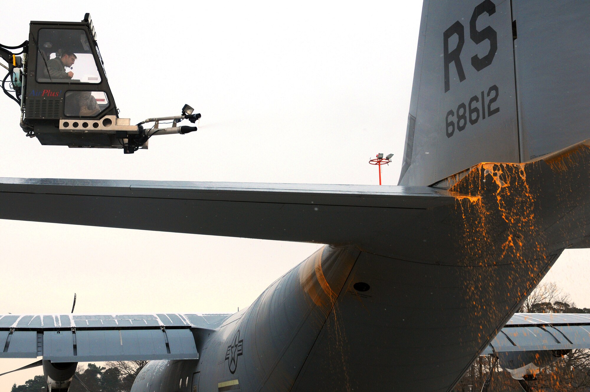 U.S. Air Force Senior Airman Brian Noonkester, crane operator, with the 86th Aircraft Maintenance Squadron, deices a C-130J at Ramstein Air Base, Germany, January 7, 2010. Aircraft deicing is a process in which liquid solutions are sprayed onto an aircraft during the winter's brutal chill to both defrost and prevent future precipitation from freezing. (U.S. Air Force photo by Airman 1st Class Brea Miller)